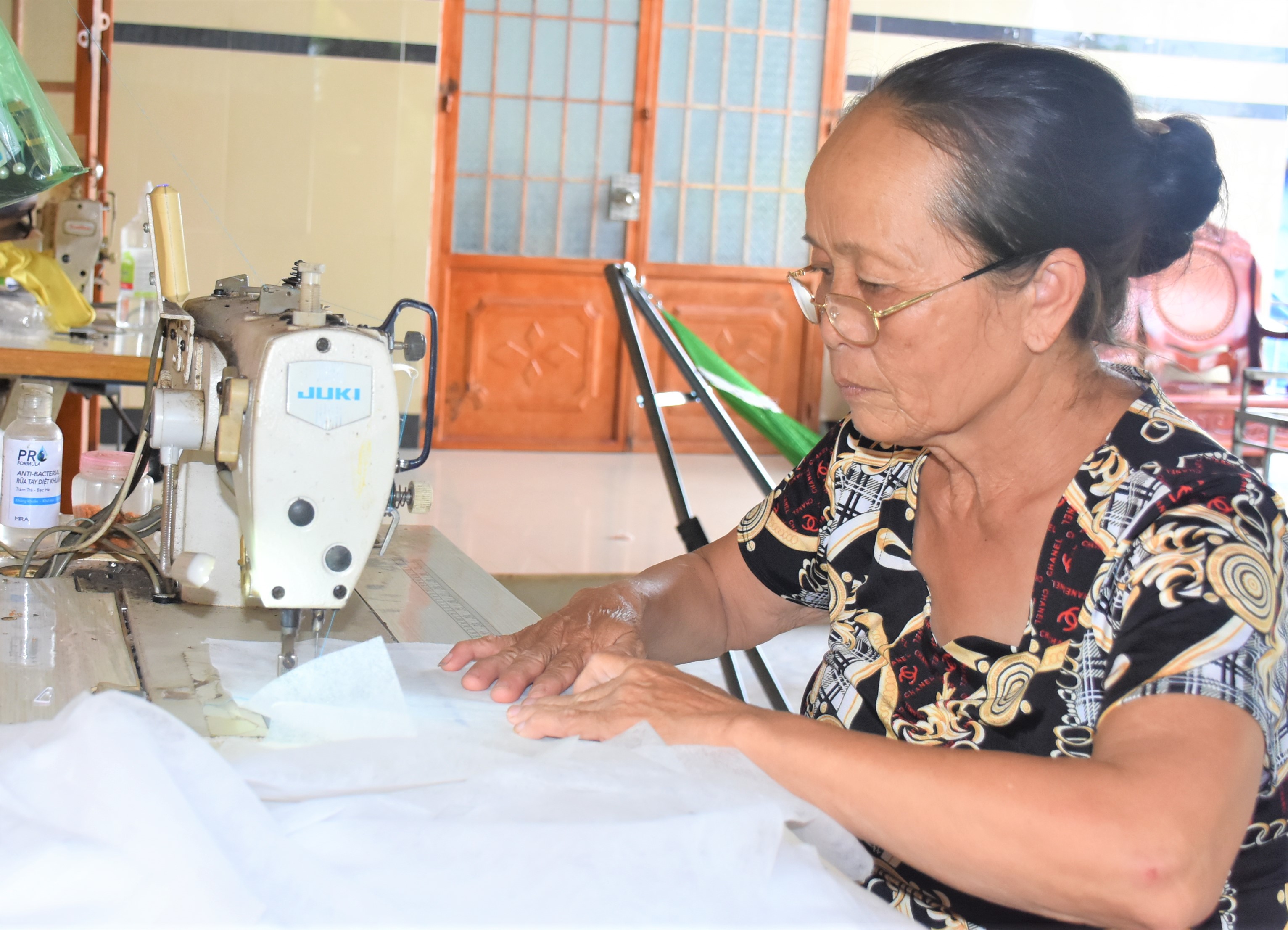 Bà Trần Thị Cam (ấp Suối Lúp, xã Bình Ba) may thảm lót ghế sô pha để có thêm thu nhập.