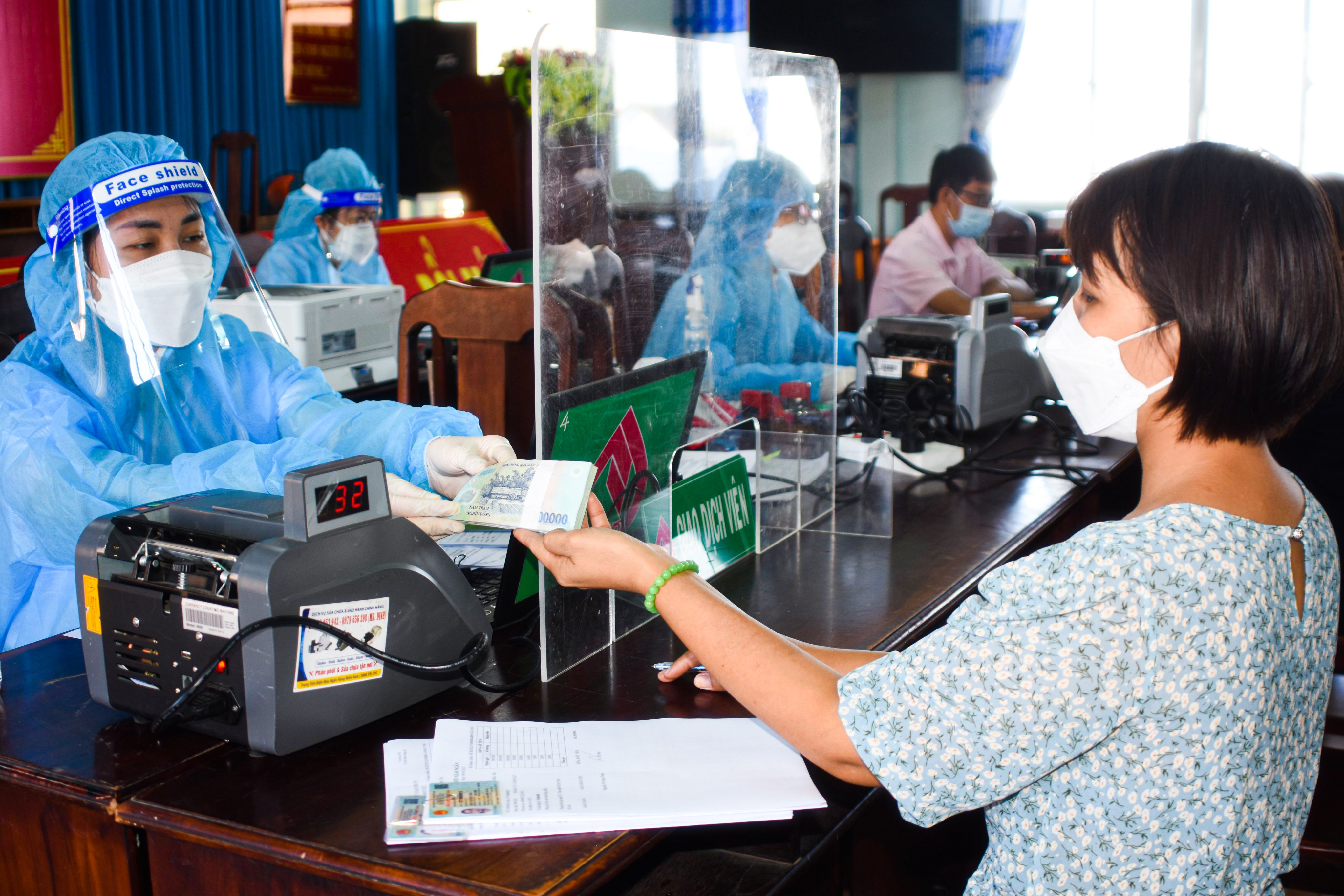 Nhân viên Phòng Giao dịch NHCSXH TP. Bà Rịa giải ngân vốn vay ưu đãi cho hộ nghèo trên địa bàn phường Phước Nguyên.
