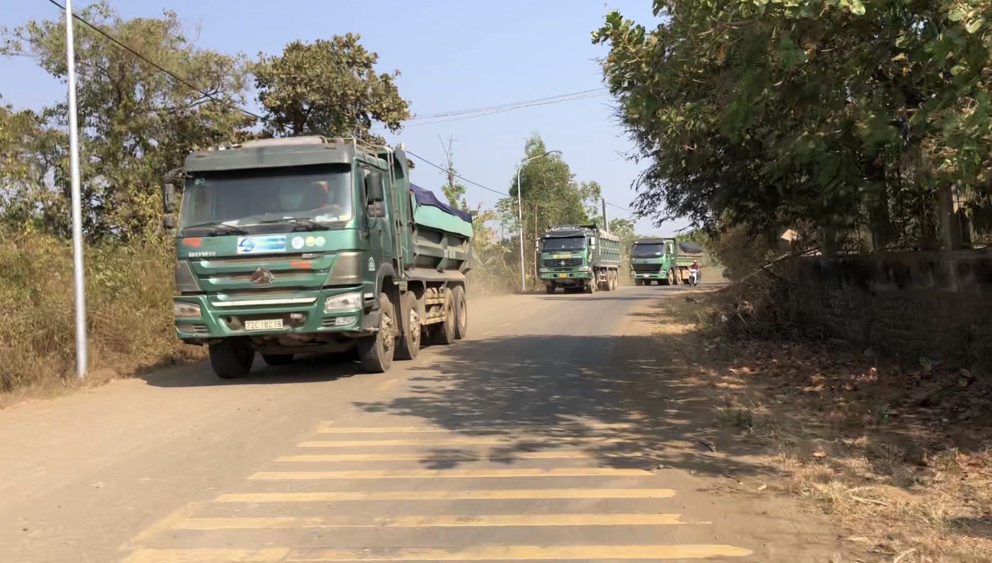Những chiếc xe ben nối đuôi nhau chở đầy đất đá trên tuyến đường Suối Nghệ - Láng Lớn. 