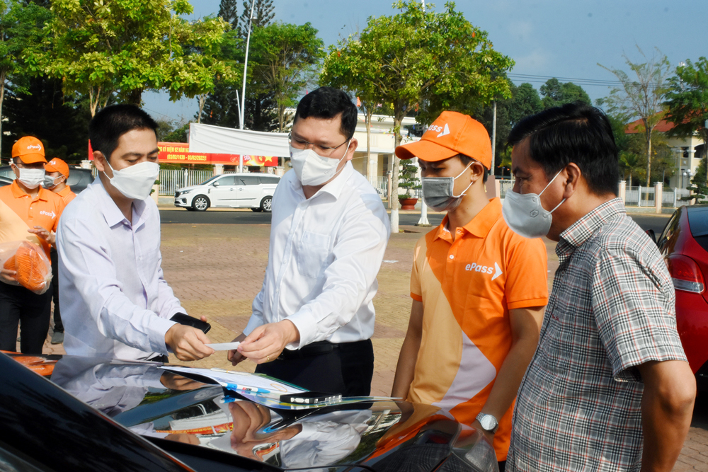 Nhân viên Viettel dán thẻ thu phí không dừng cho xe ô tô của cán bộ, công chức, viên chức huyện Châu Đức. Ảnh: NHẬT LINH