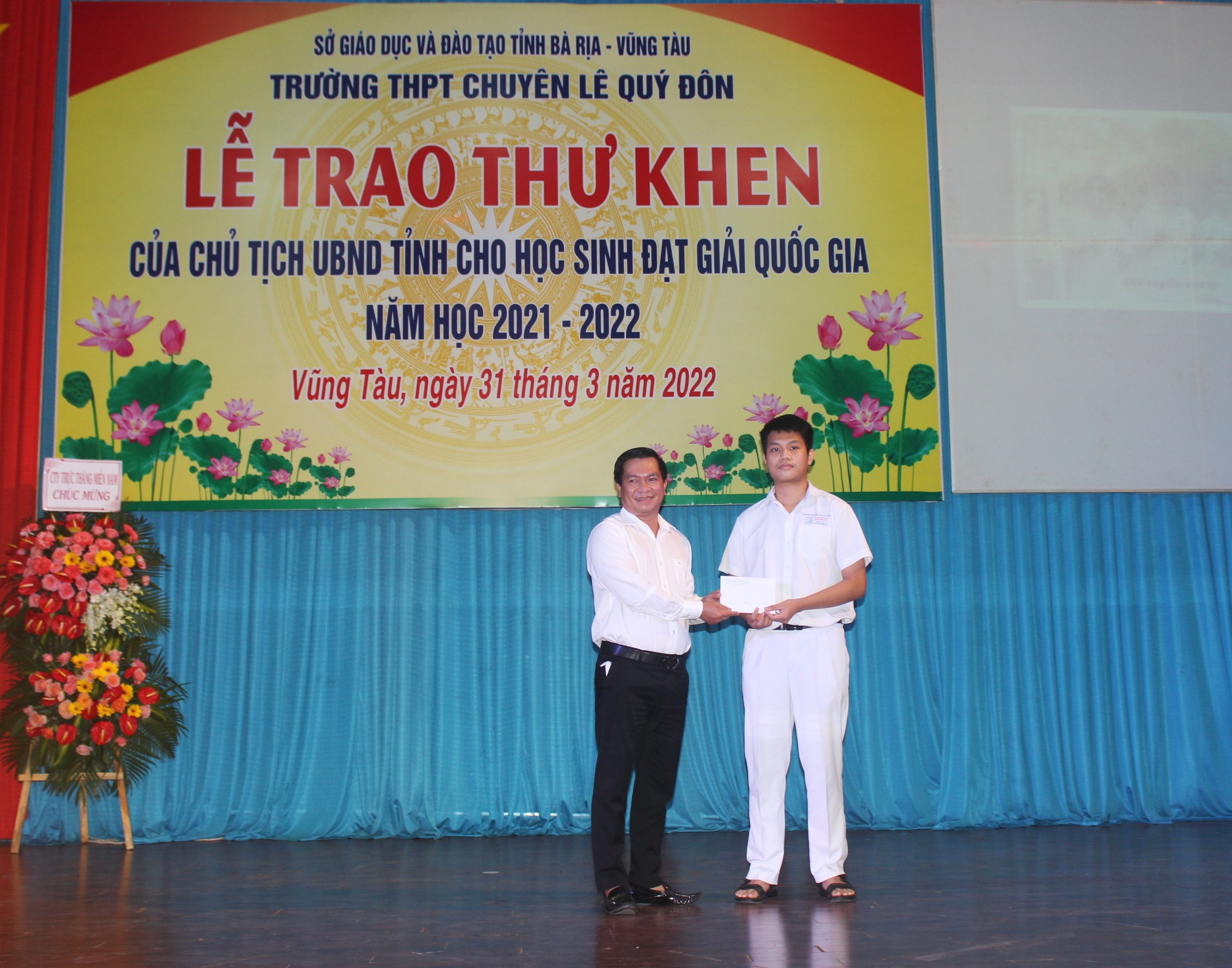 Ông Nguyễn Đức Lợi, Trưởng Ban đại diện Hội cha mẹ học sinh Trường THPT chuyên Lê Quý Đôn trao 20 triệu đồng cho em Nguyễn Văn Duy, học sinh đạt giải Nhất môn Toán trong Kỳ thi học sinh giỏi Quốc gia năm học 2021-2022.