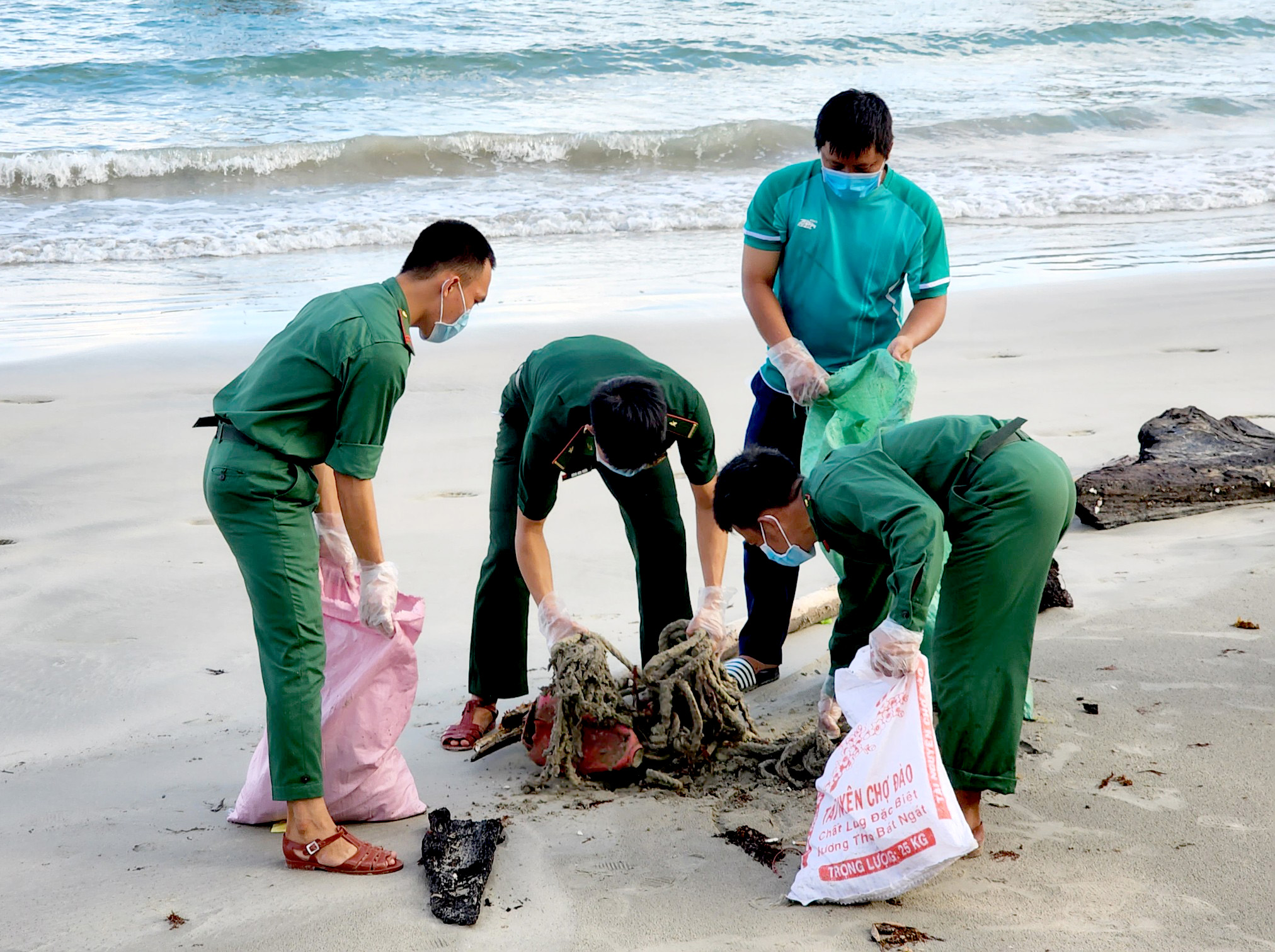 Cán bộ, chiến sĩ Đồn Biên phòng Côn Đảo và ĐVTN thu gom rác thải tại bờ biển huyện Côn Đảo.