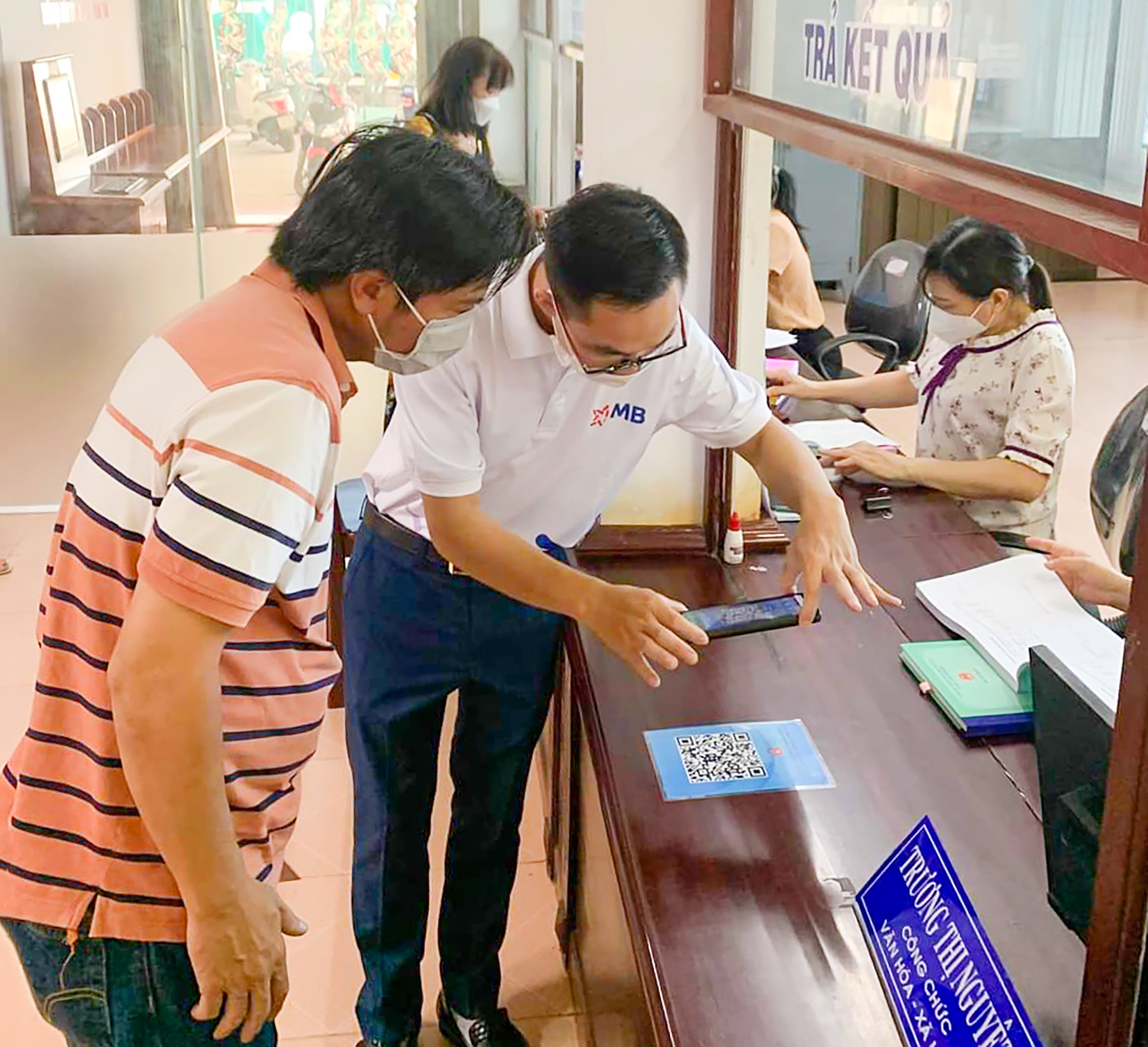 Nhân viên MB Bank hướng dẫn người dân thanh toán không dùng tiền mặt bằng mã QR tại trụ sở UBND phường 7, TP.Vũng Tàu.