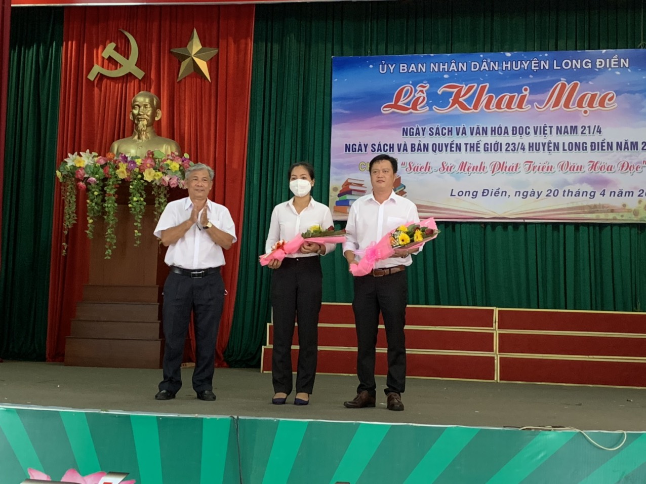 Ông Vương  Quốc Thịnh, Phó Trưởng phòng Văn hóa, Thông tin huyện Long Điền (bìa trái) tặng hoa cho Ban giám khảo cuộc thi Vẽ tranh theo sách với chủ đề “Vì một hành tinh xanh”. 