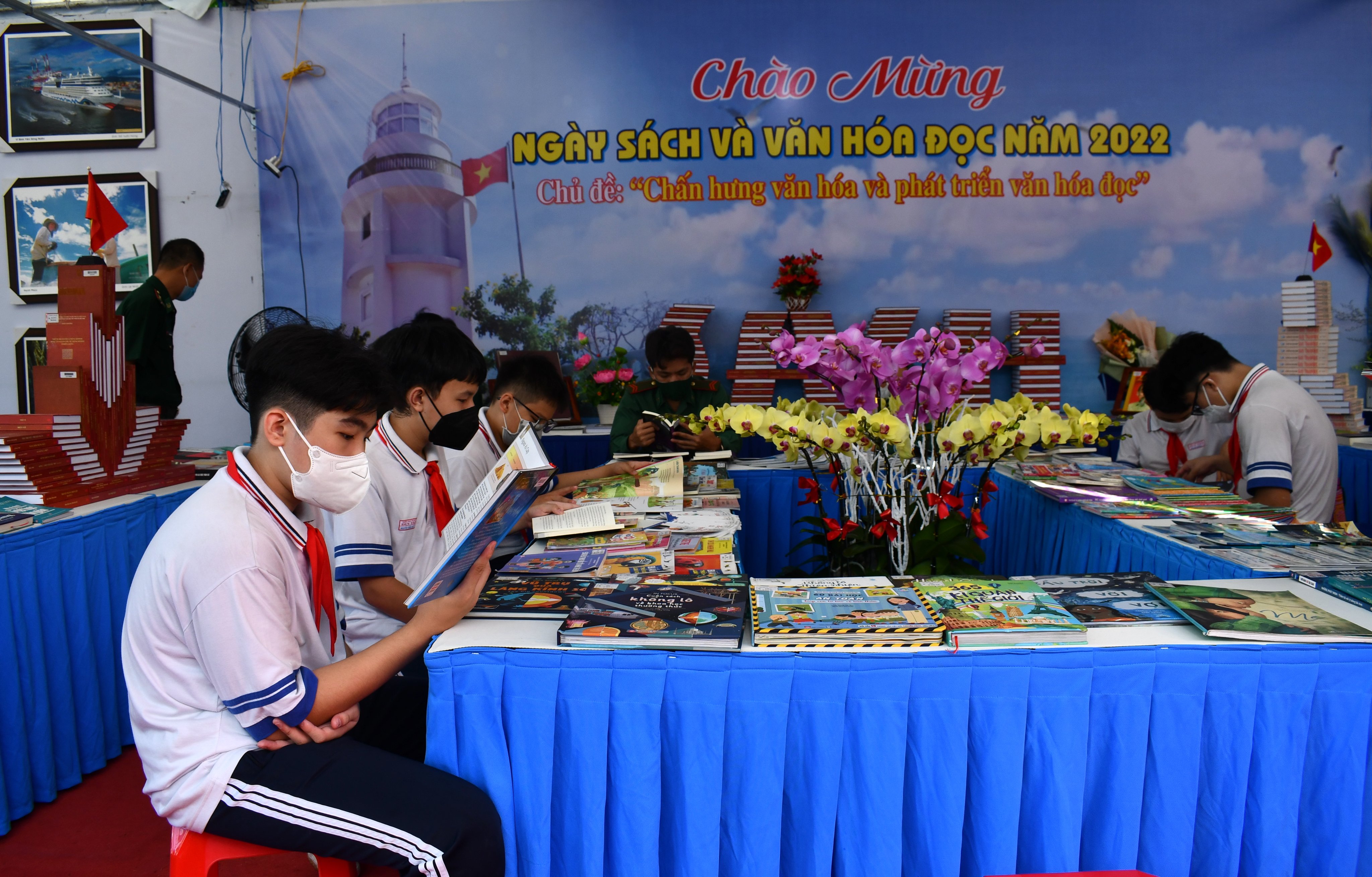 Các em HS đọc sách tại các gian hàng triển lãm sách sáng 22/4.