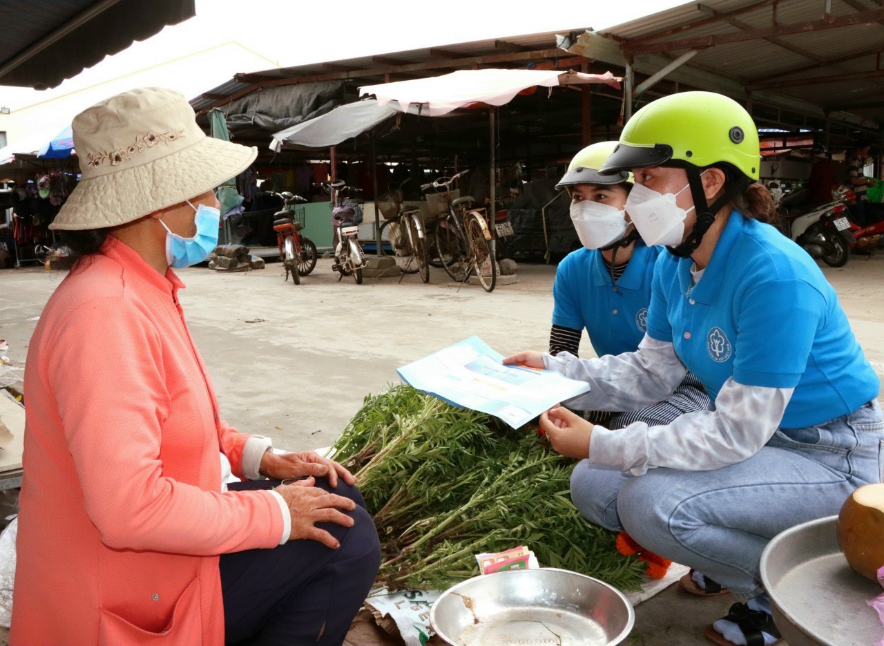 Chuyên viên BHXH huyện Đất Đỏ tuyên truyền vận động người tham gia BHXH tại chợ Đất Đỏ.