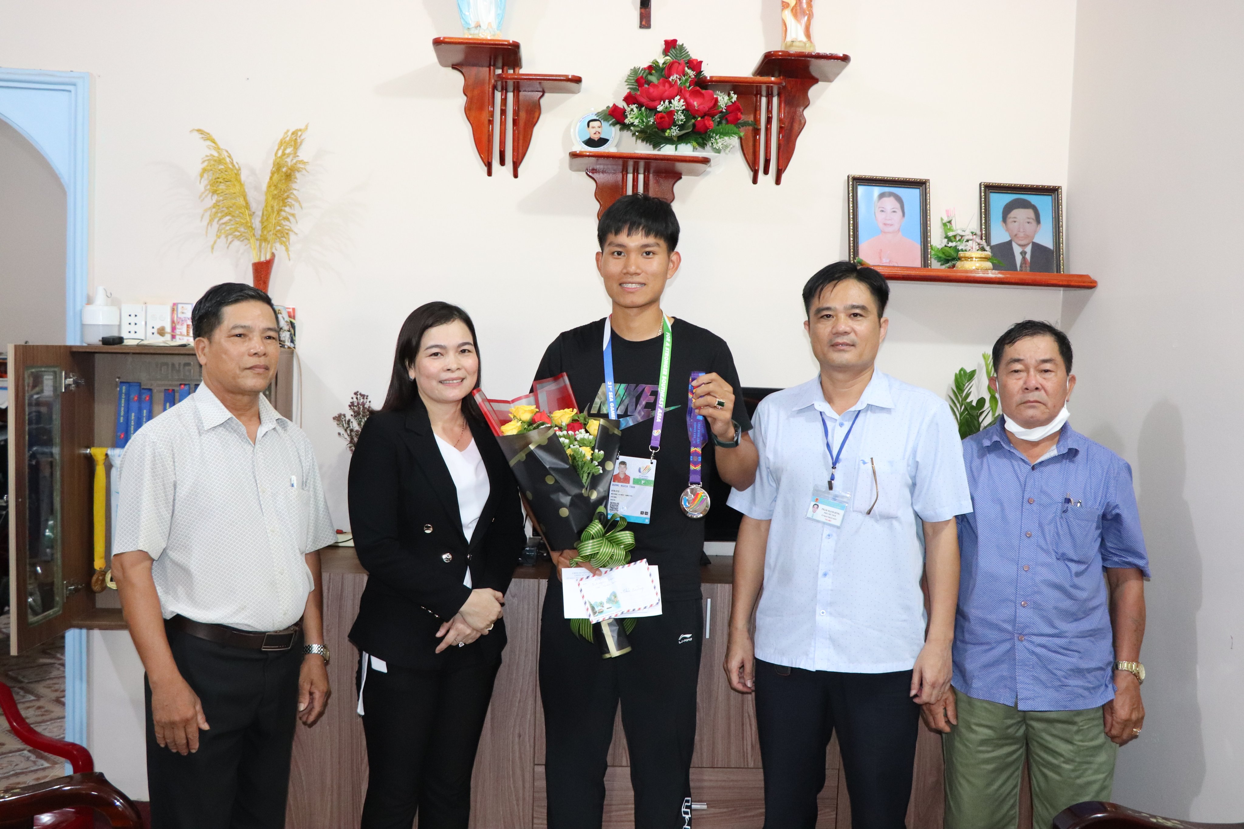 Bà Nguyễn Thị Kim Nga, Chủ tịch UBND xã Xuân Sơn tặng quà VĐV Trần Dương Nghĩa.
