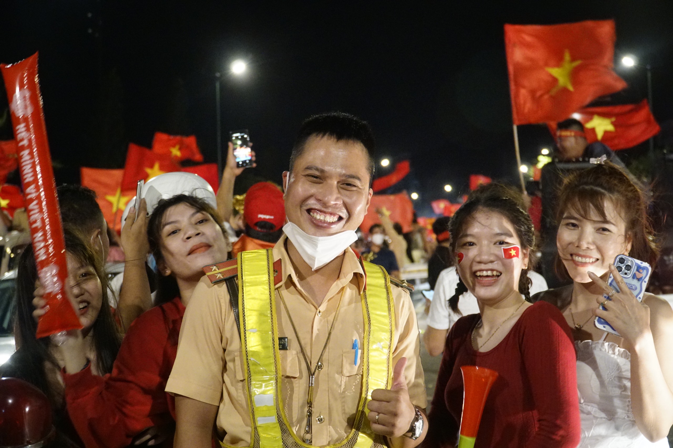 Một chiến sĩ CSGT vui vẻ chụp hình lưu niệm của các nữ cổ động viên. 