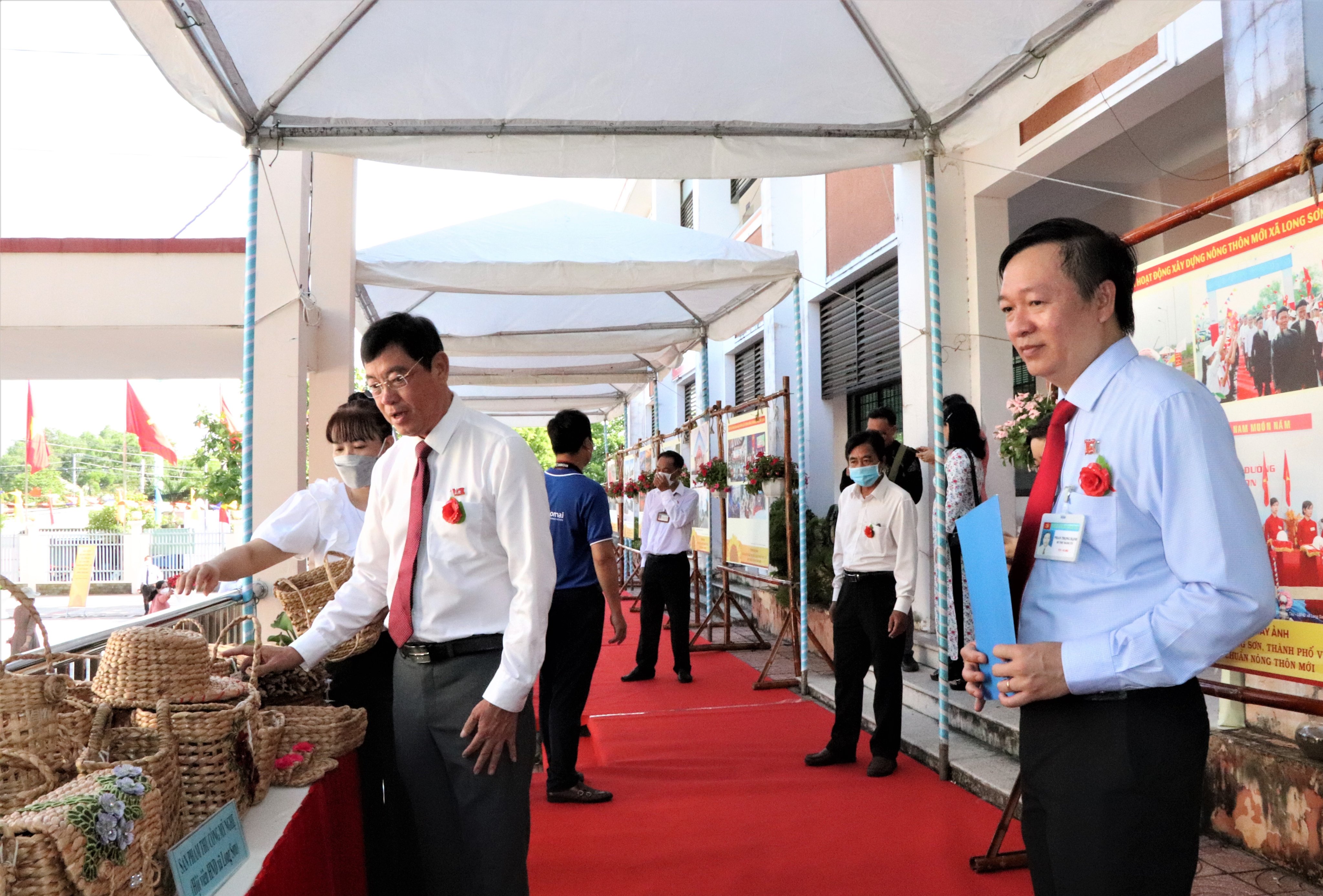 Ông Trần Trần Đình Khoa (bên trái), Bí thư Thành ủy Vũng Tàu xem gian hàng trưng bày các sản phẩm đan lát từ cây lục bình. Mô hình hình này đã tạo việc làm, tăng thêm thu nhập cho người dân Long Sơn.