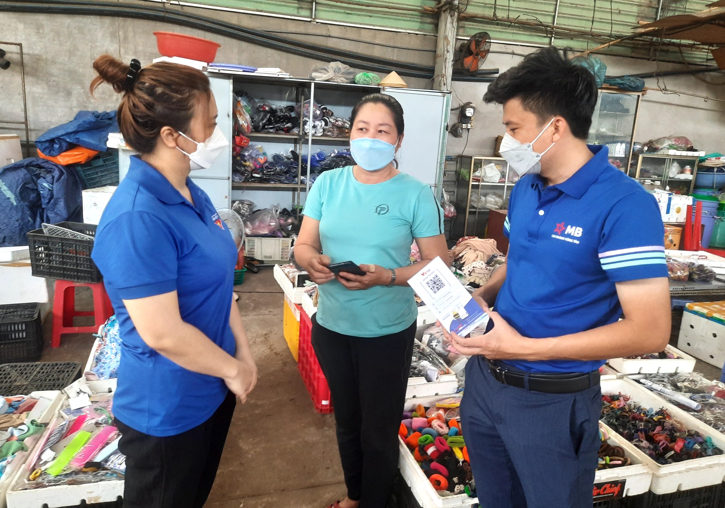 Lực lượng ĐVTN phối hợp nhân viên ngân hàng MB hướng dẫn người dân cài đặt, chợ Năm Tầng (phường 7, TP.Vũng Tàu) sáng 22/5.