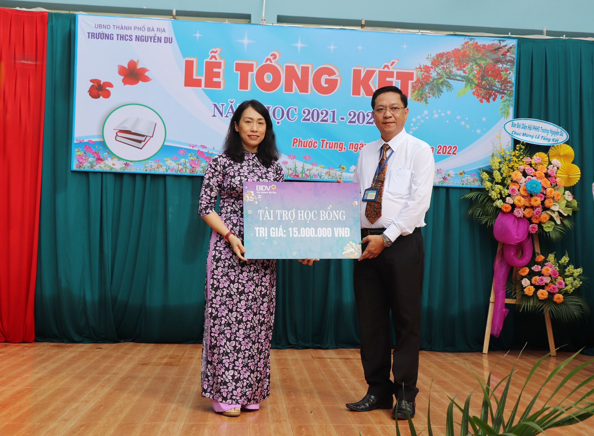 Bà Nguyễn Thanh Thủy, Giám đốc BIDV Chi nhánh Bà Rịa trao bảng tượng trưng số tiền 15 triệu đồng tặng nhà trường để trao học bổng cho học sinh.