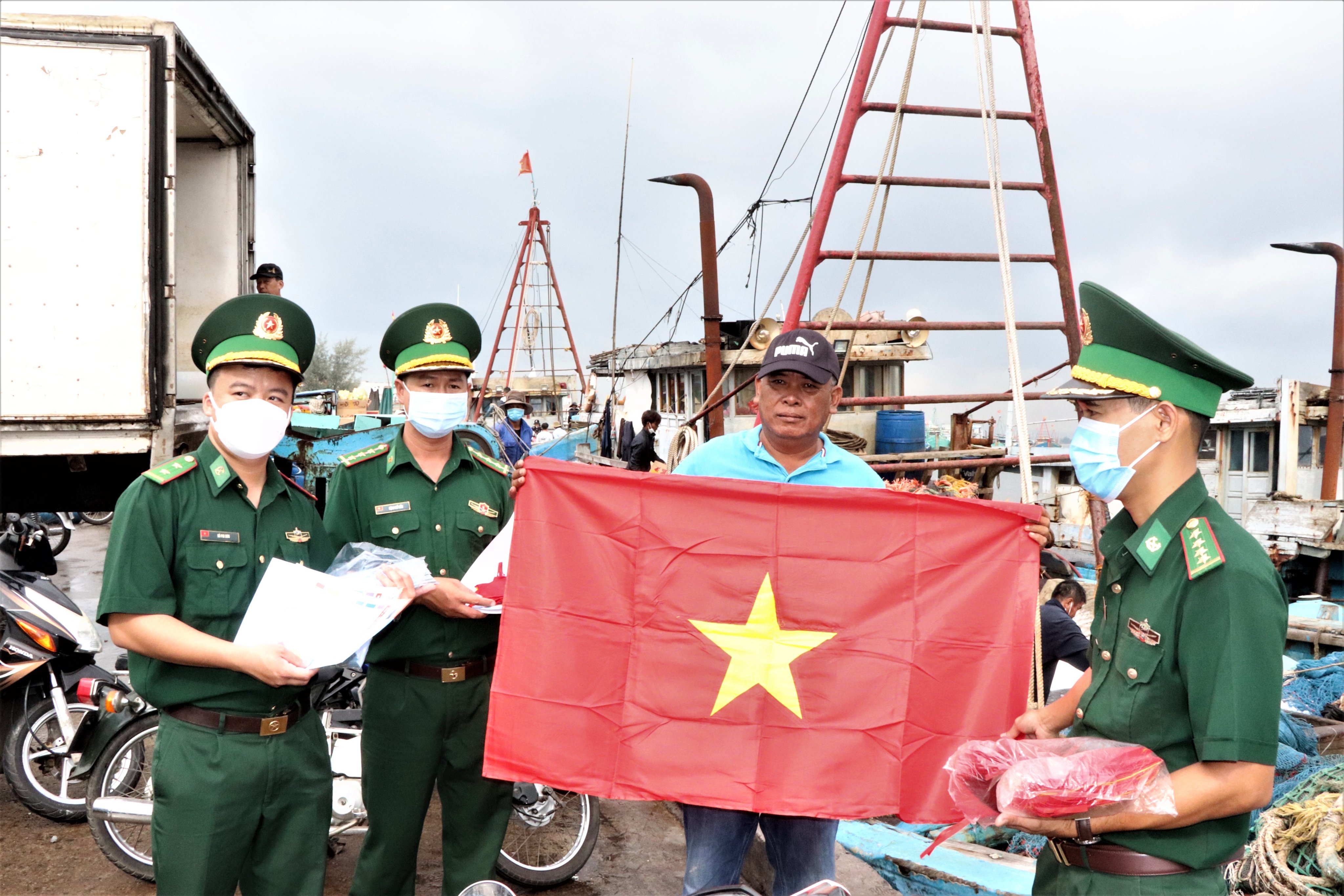 Cán bộ, chiến sĩ Đồn Biên phòng Phước Tỉnh tặng cờ Tổ quốc cho Thuyền trưởng tàu cá BV 928191 TS Lê Đức Hòa tại cảng cá Tân Phước, xã Phước Tỉnh, huyện Long Điền. 