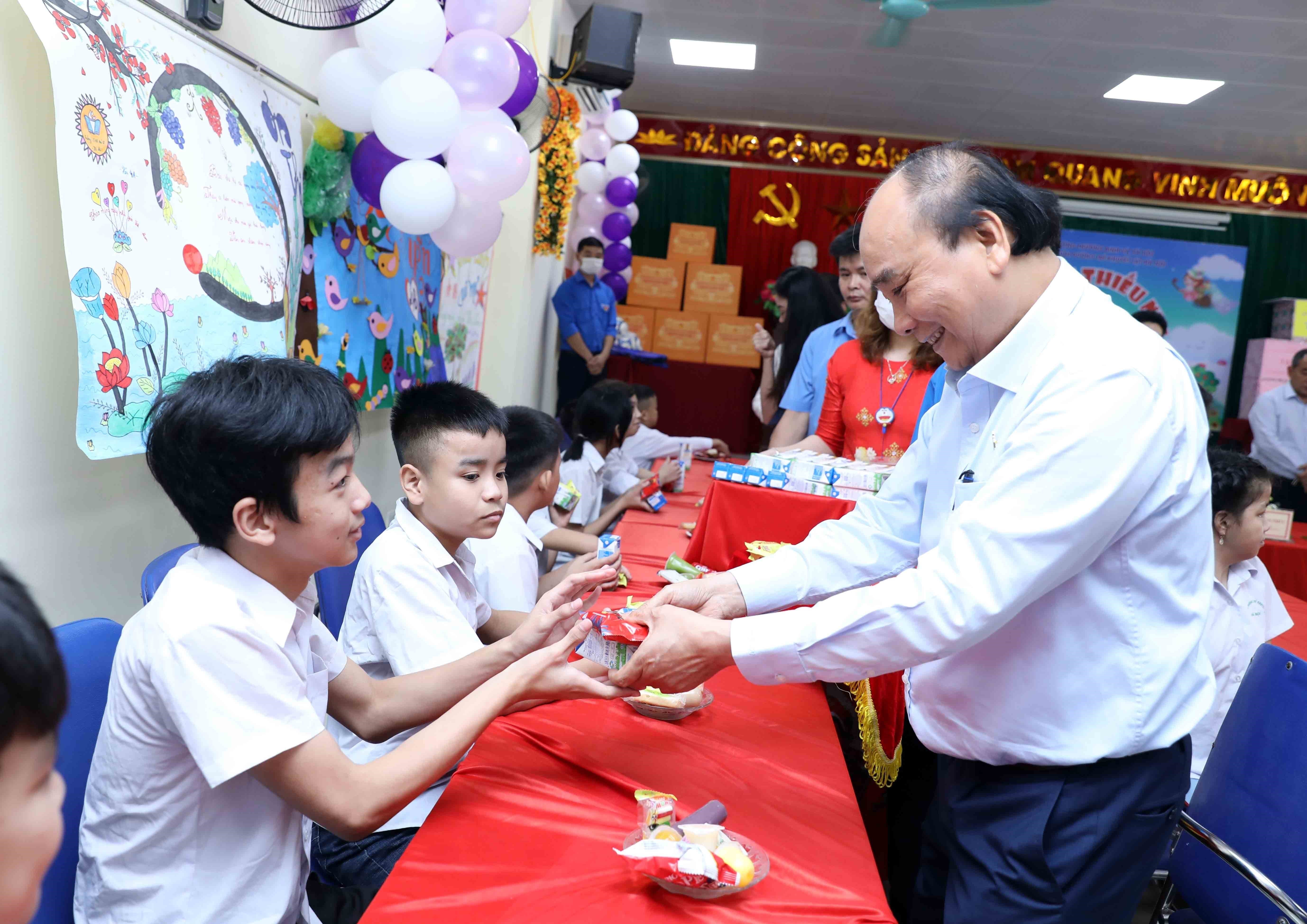 Chủ tịch nước Nguyễn Xuân Phúc tặng quà cho trẻ khuyết tật.  Ảnh: AN ĐĂNG