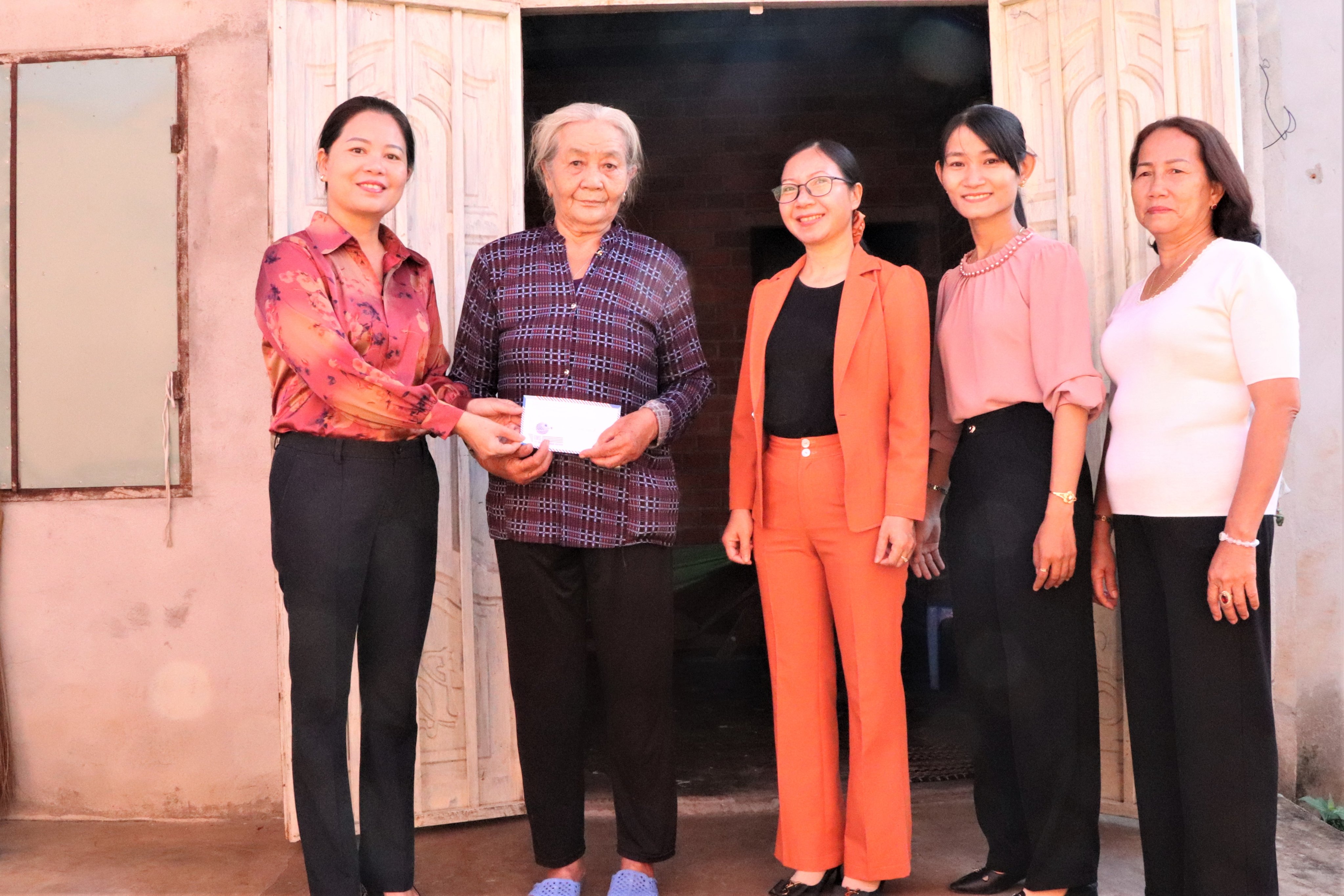 Bà Bùi Thị Sen (bên trái), Chủ tịch Hội LHPN huyện Châu Đức trao tiền cho bà Lê Thị Vàng (ấp Bình Đức, xã Bình Ba).