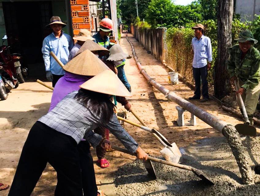 Hội viên phụ nữ xã Bưng Riềng cùng chung tay làm bê tông nông thôn.