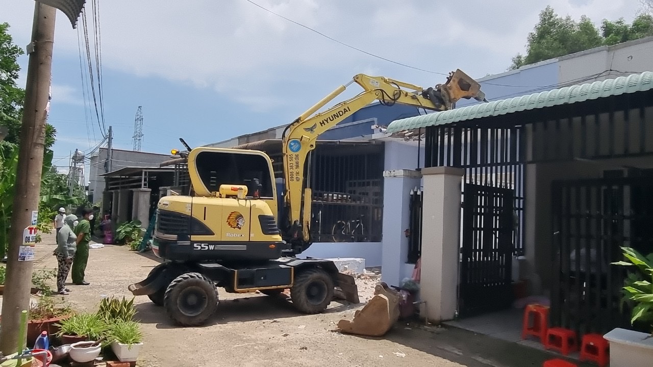 Máy xúc thực hiện san ủi một nhà cấp 4 xây dựng trái phép trên đất nông nghiệp tại khu phố Tân Phú, phường Phú Mỹ 