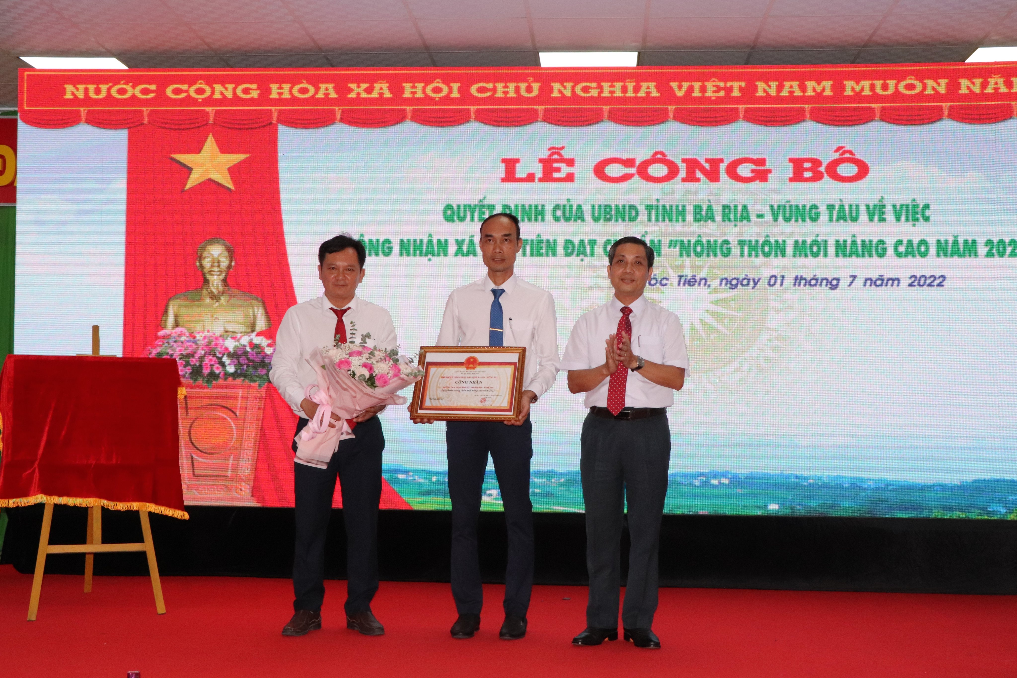 Thừa ủy quyền của Chủ tịch UBND tỉnh, ông Nguyễn Kế Toại (bên phải), Phó Chủ tịch UBMTTQ Việt Nam tỉnh trao Bằng công nhận xã Tóc Tiên đạt chuẩn NTM nâng cao năm 2021.