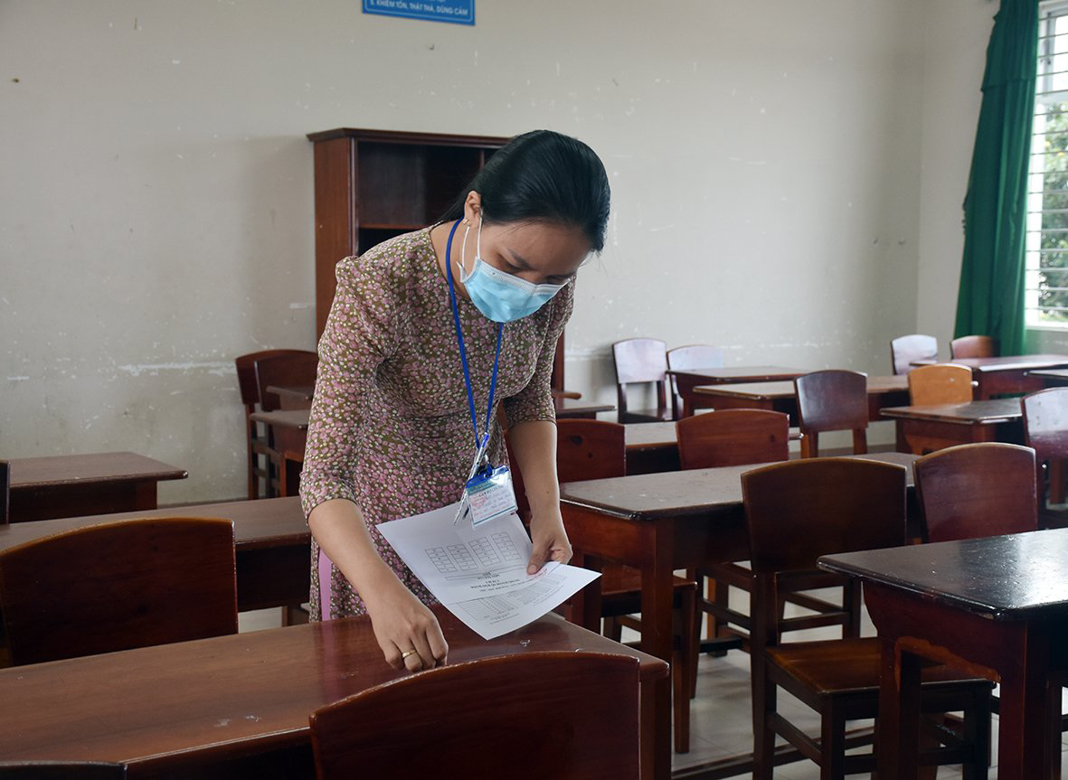 Giáo viên sắp xếp chỗ ngồi theo số báo danh cho các thí sinh trước giờ thi tại Trường THPT Minh Đạm, huyện Long Điền. Ảnh: QUANG VINH