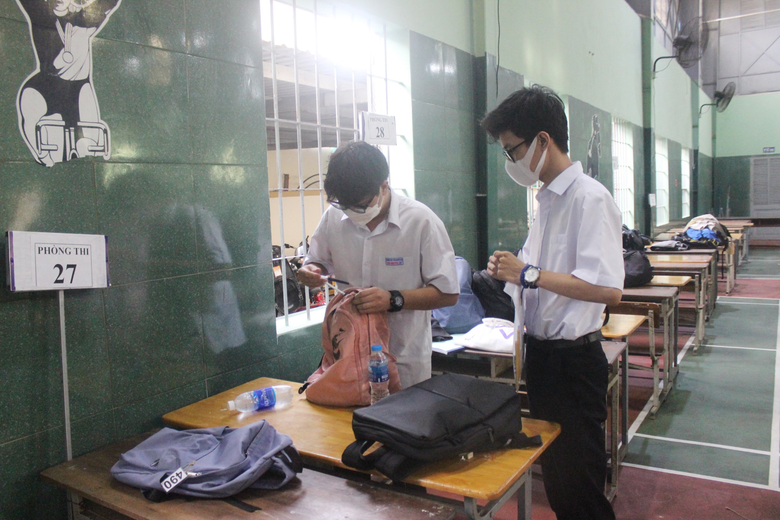 Trước đó, thí sinh được phát thẻ giữ đồ và được hướng dẫn để những vật dụng không mang vào phòng thi ở khu vực bảo quản, cách phòng thi khoảng 25m. Ảnh: KHÁNH CHI