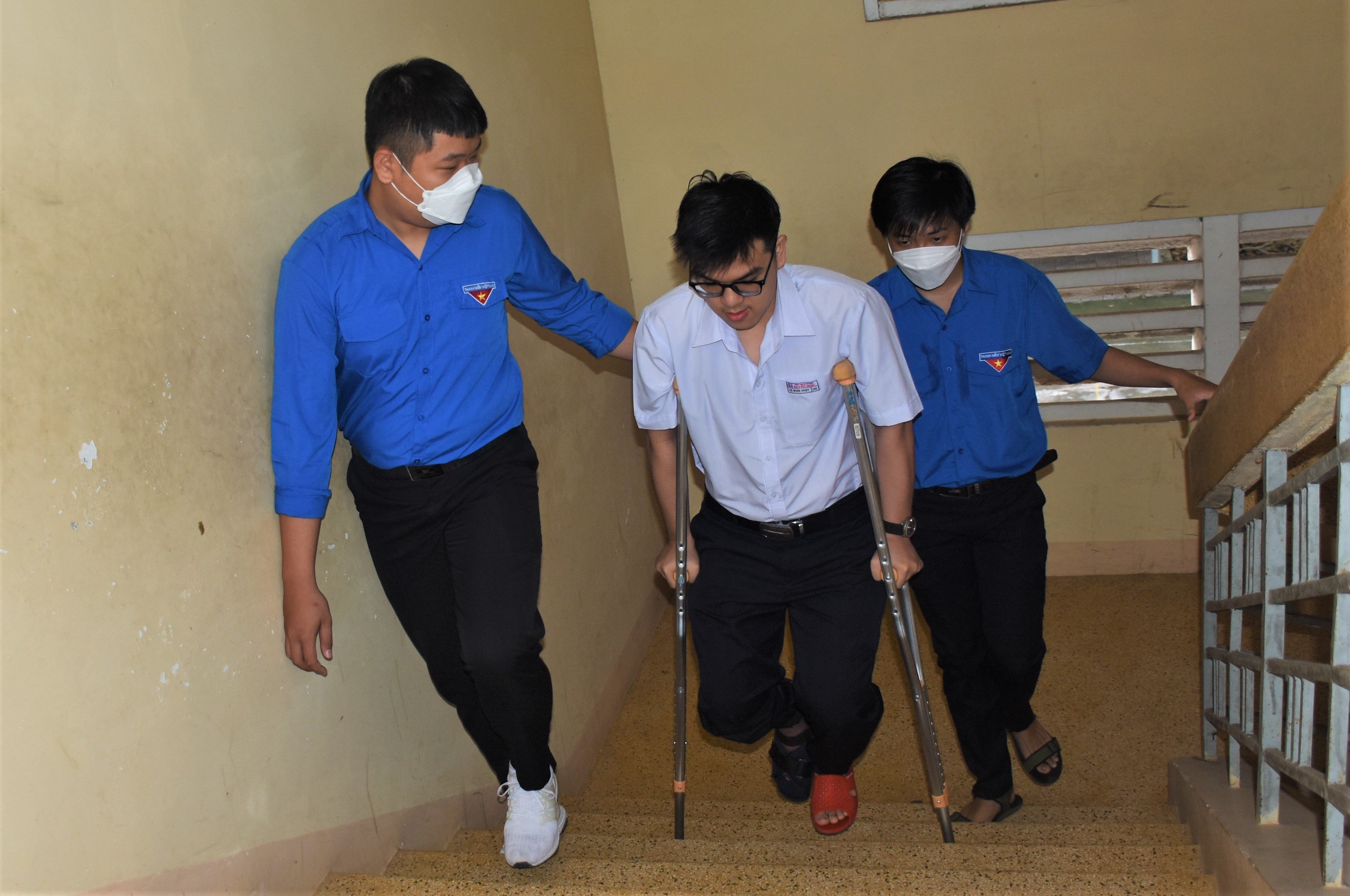 Thí sinh Lê Minh Nhật. HS lớp 12A1 Trường THPT Xuyên Mộc bị gãy chân được các tình nguyện viên hỗ trợ di chuyển lên phòng thi tại lầu 3 điểm thi Trường THPT Xuyên Mộc.