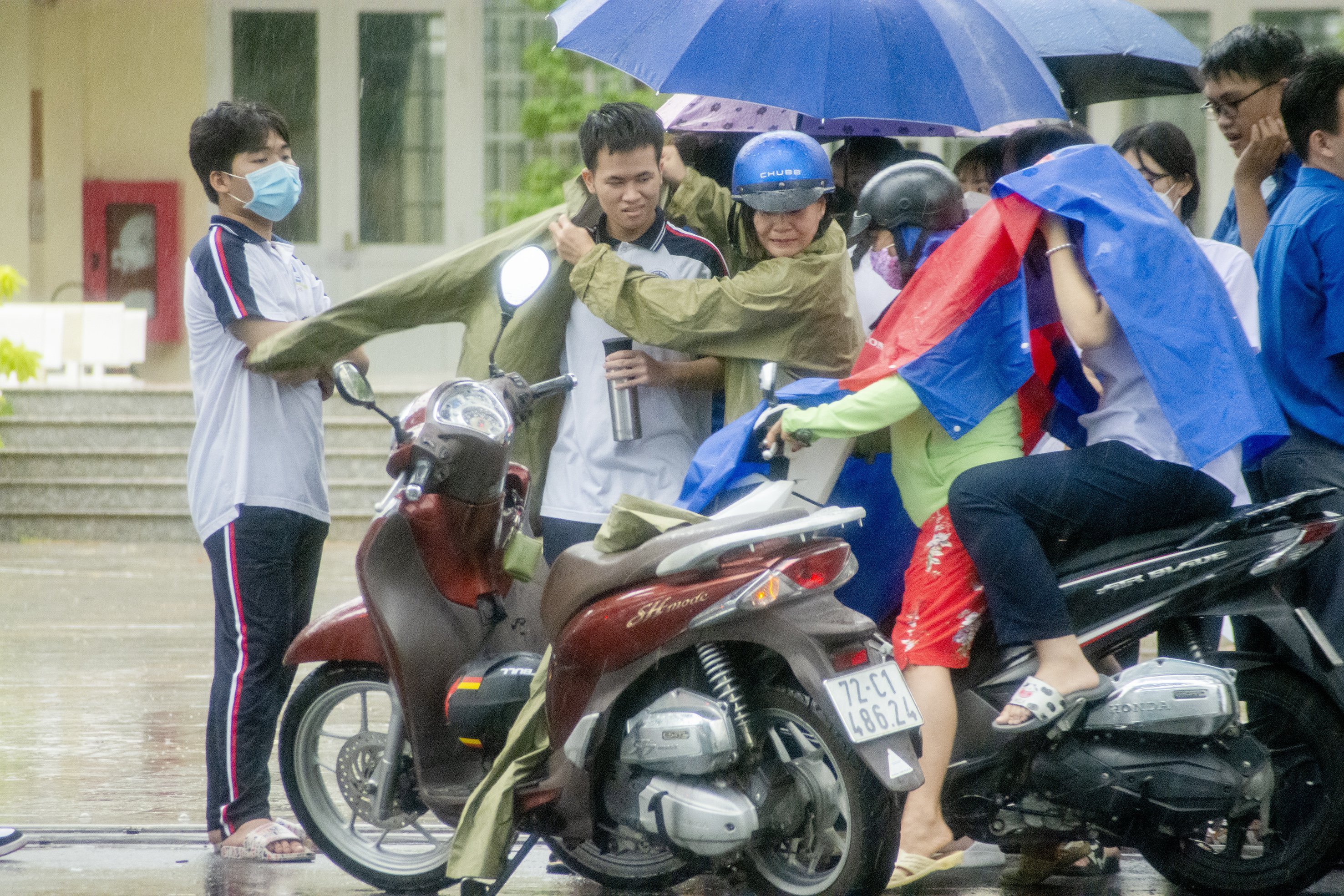 TS tại điểm thi Trường THPT Trần Nguyên Hãn (TP. Vũng Tàu) ra về sau khi kết thúc môn thi cuối cùng dưới cơn mưa tầm tã chiều 8/7. Ảnh: MẠNH THẮNG