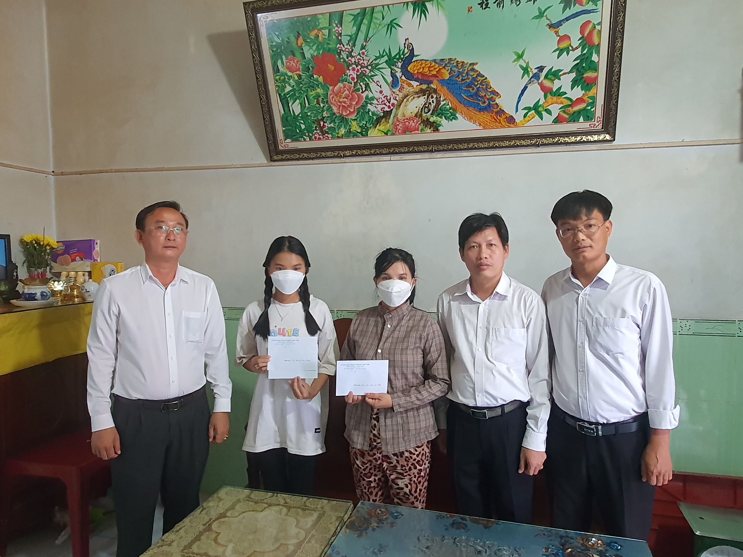 Ông Lê Hồng Ngọc (trái) và đoàn thăm, trao quà tới gia đình em Phạm Trần Hoài Thu.