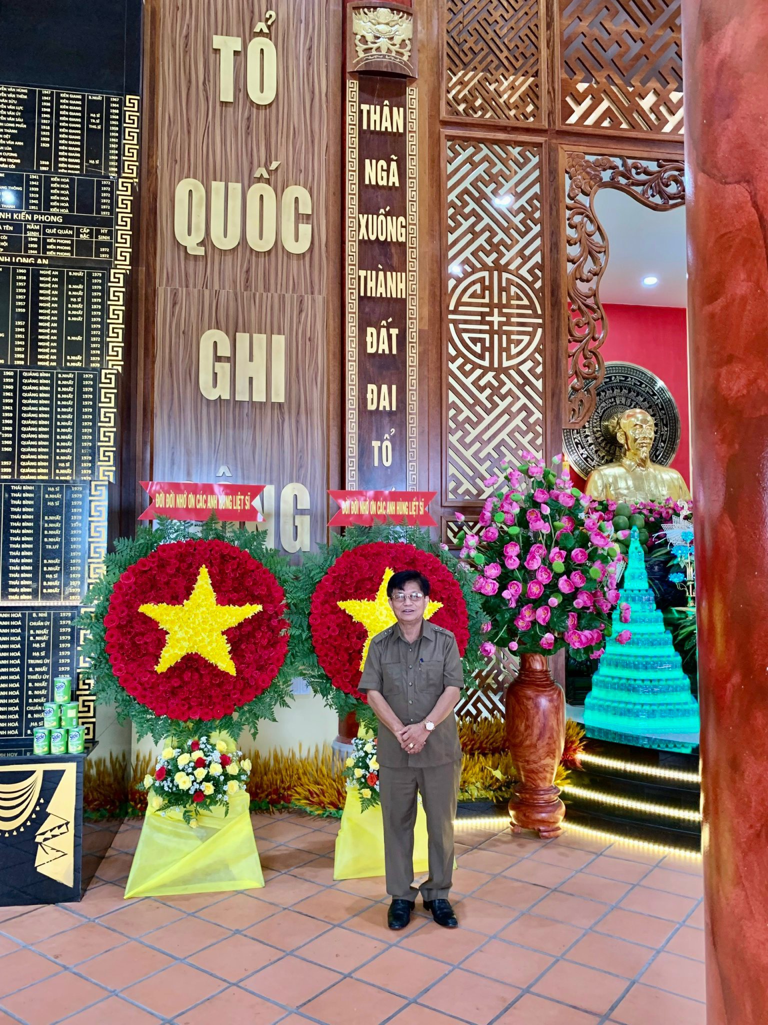 Nhà thơ, nhà báo Đại tá Trần Thế Tuyển, tại Đền thờ liệt sĩ Long Khốt, trước một vế câu đối do anh viết: “Thân ngã xuống thành đất đai Tổ quốc”.