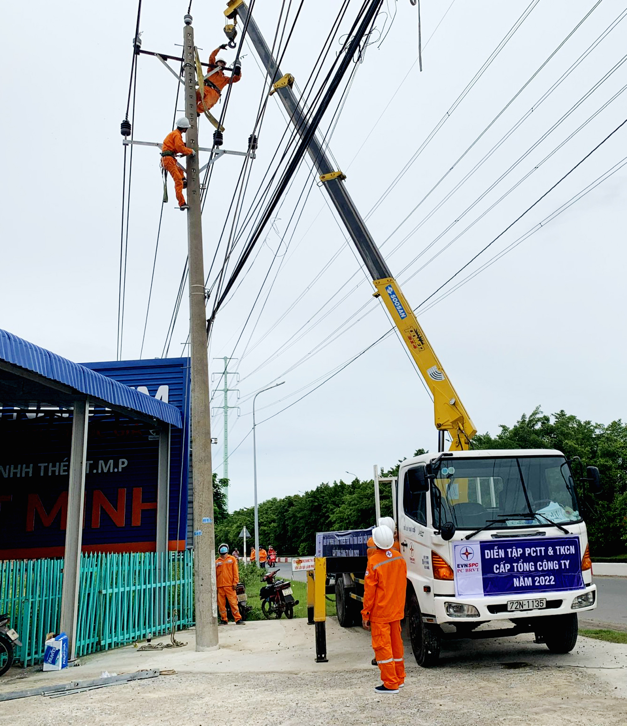 Nhân viên ngành điện diễn tập khắc phục sự cố giả định cột điện bị nghiêng do ảnh hưởng của mưa bão.