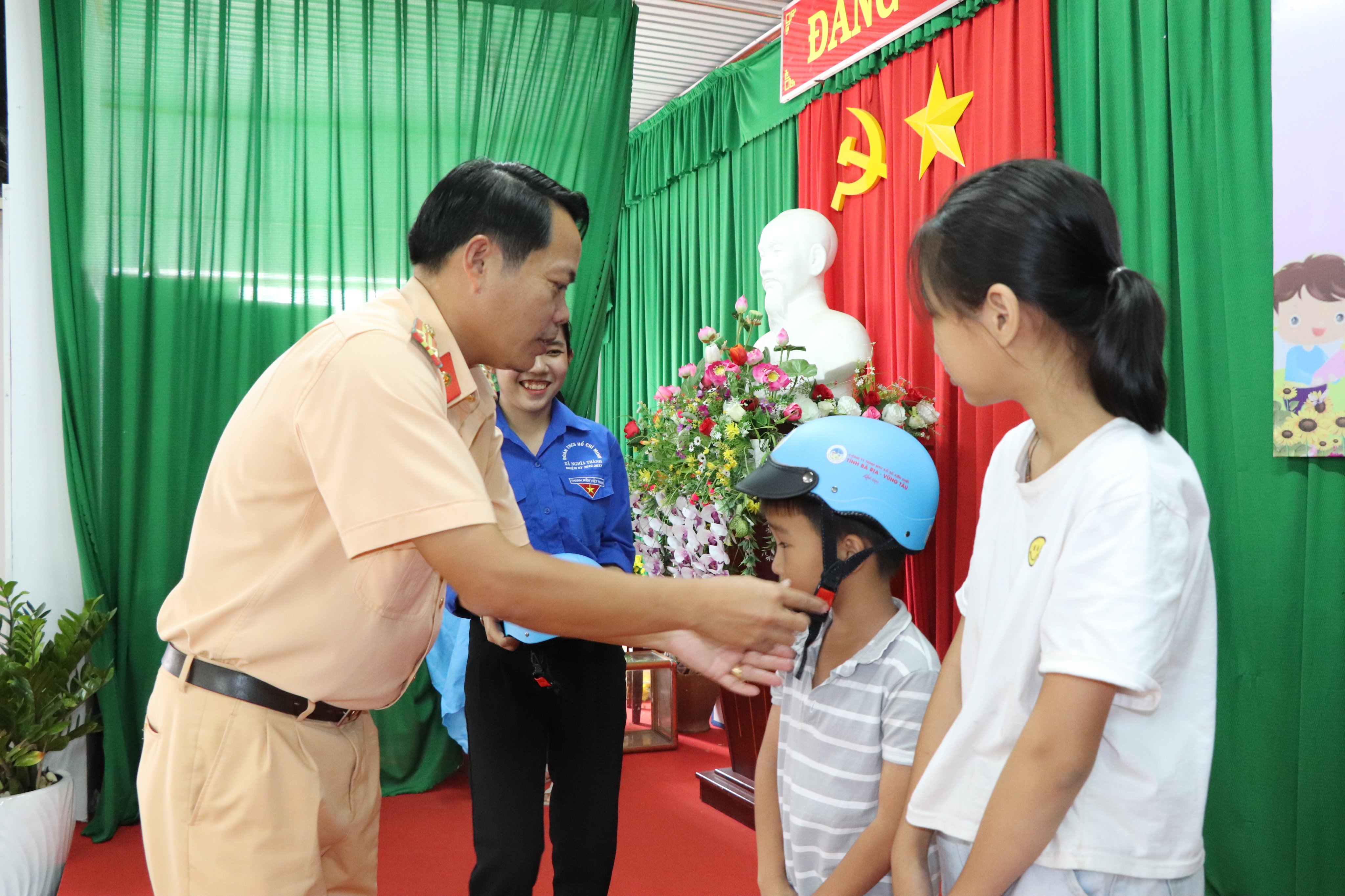 Trung tá Nguyễn Minh Hoàng, cán bộ Cảnh sát giao thông-Trật tự Công an huyện Châu Đức tặng mũ bảo hiểm cho các thí sinh trả lời đúng câu hỏi phụ.