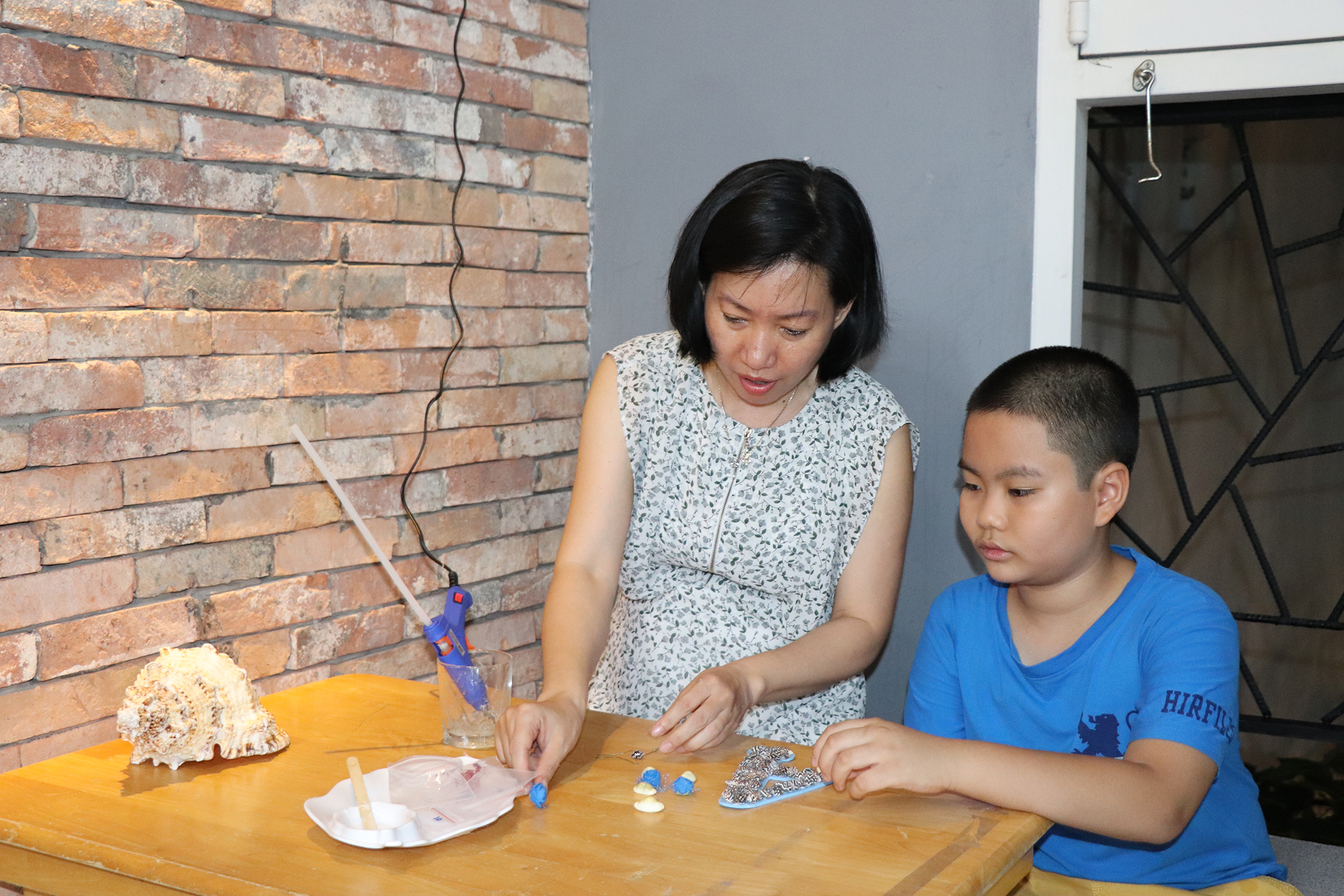Cô Song Khê cẩn thận hướng dẫn các em trang trí sản phẩm.