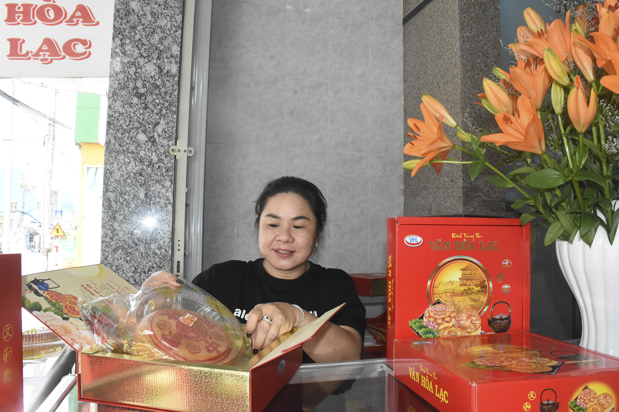 Chị Văn Mỹ Linh, chủ cơ sở bánh Trung thu Văn Hòa Lạc chuẩn bị bánh giao cho khách.