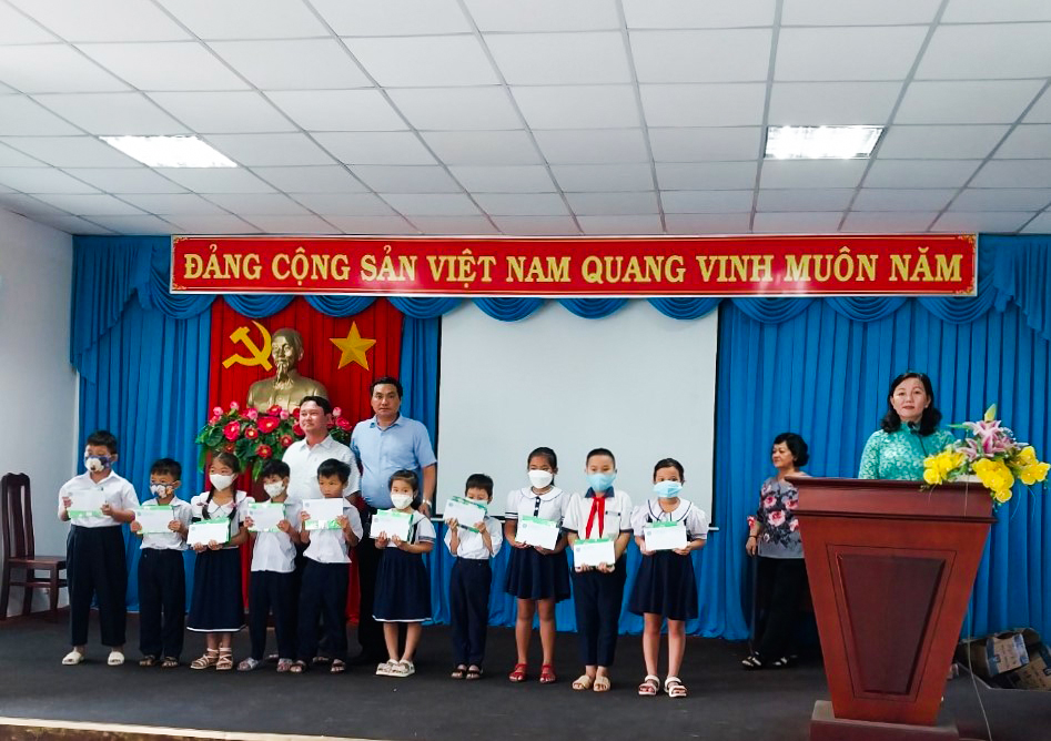Ông Trần Quốc Nhẫn (bên phải), Phó Chủ tịch UBND TT. Long Hải trao quà cho HS tiểu học và THCS trên địa bàn thị trấn.