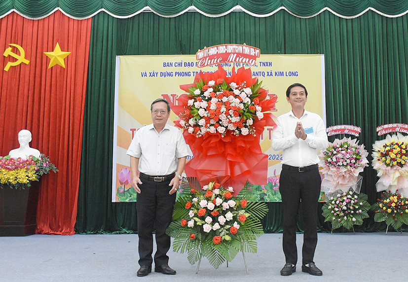 Ông Huỳnh Bách Chiến, Phó Trưởng Ban Tổ chức Tỉnh ủy tặng hoa chúc mừng xã Kim Long (huyện Châu Đức) tại ngày hội “Toàn dân bảo vệ an ninh Tổ quốc”. Ảnh: NGỌC BÍCH