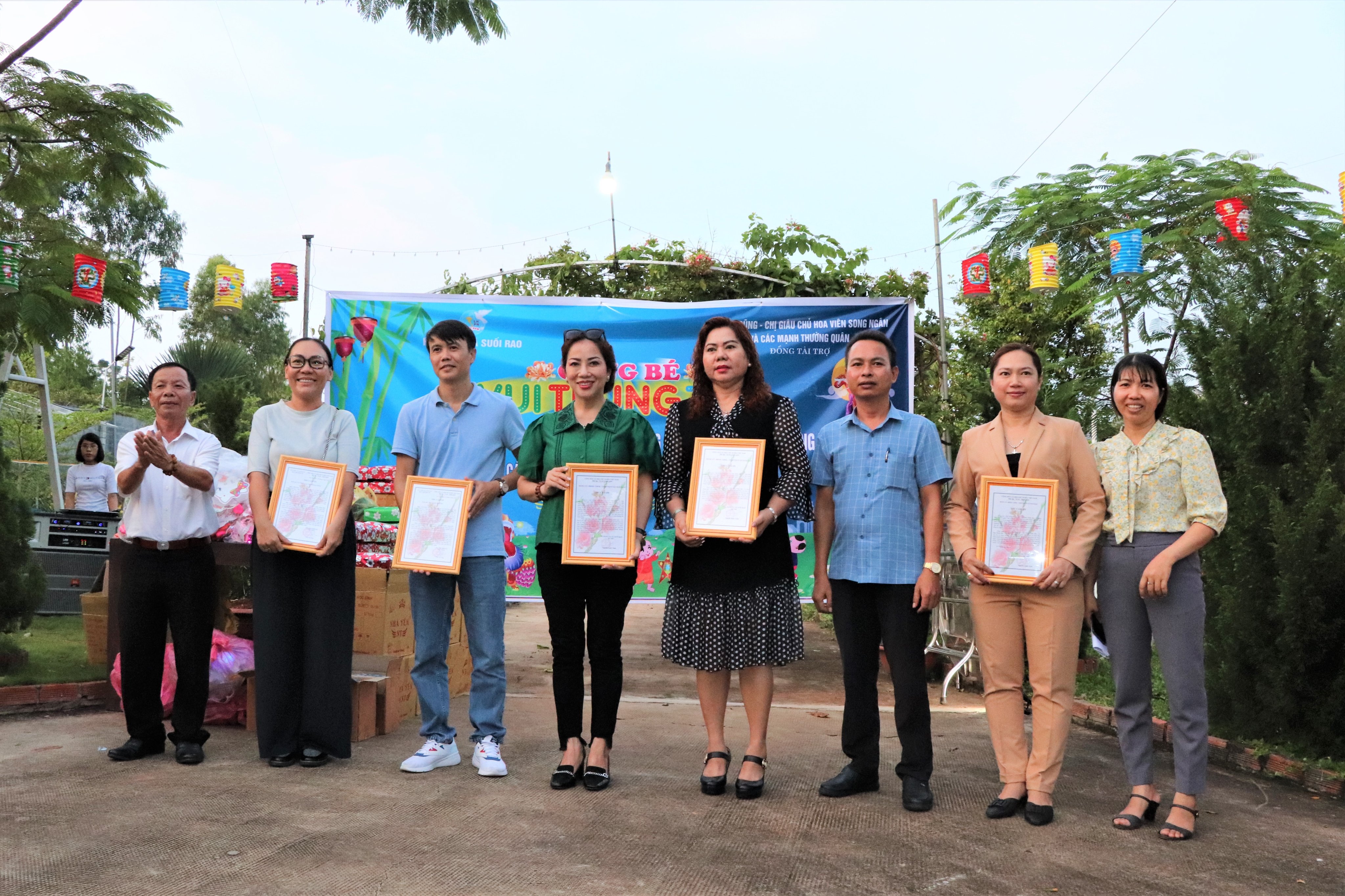 Ông Nguyễn Quốc Toản (bên trái), Bí thư Đảng ủy xã Suối Rao trao Thư cảm ơn cho các nhà tài trợ thực hiện chương trình trung thu cho trẻ em trong xã.