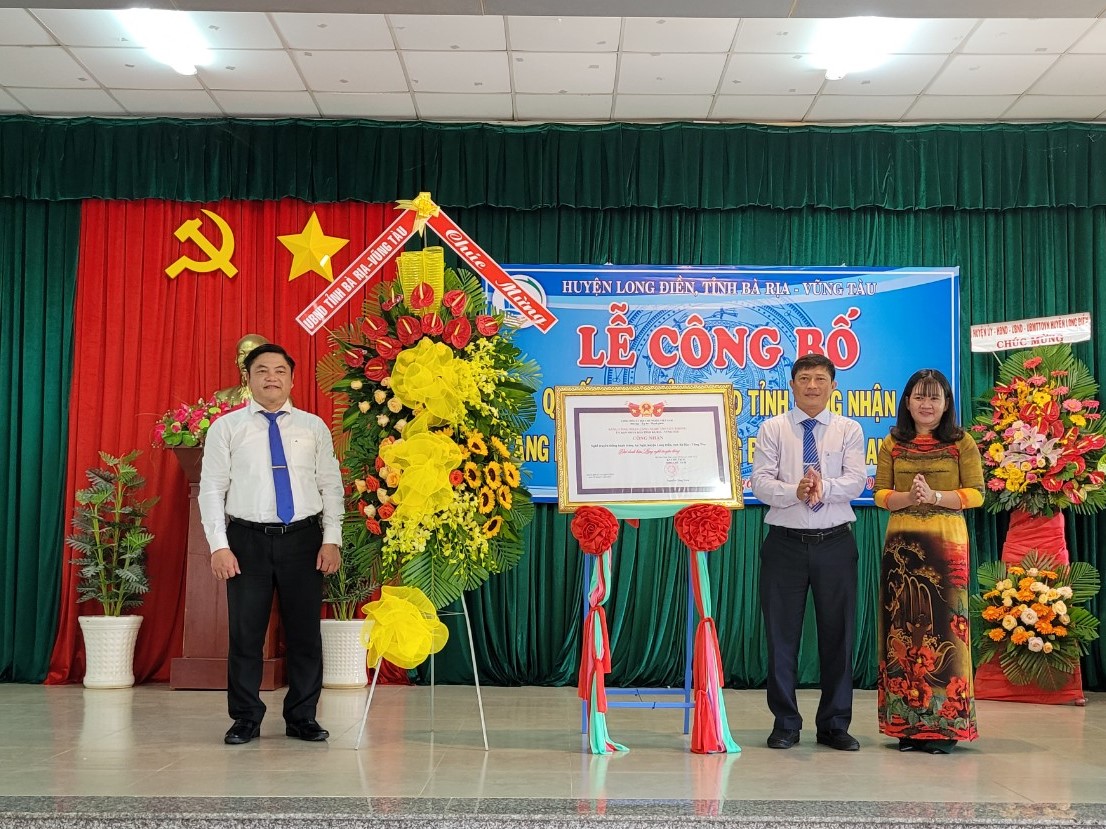 Ông Vũ Ngọc Đăng (bìa trái) Phó Chánh văn phòng điều phối chương trình nông thôn mới tỉnh trao Quyết định cho UBND xã An Ngãi công nhận làng nghề bánh tráng An Ngãi.