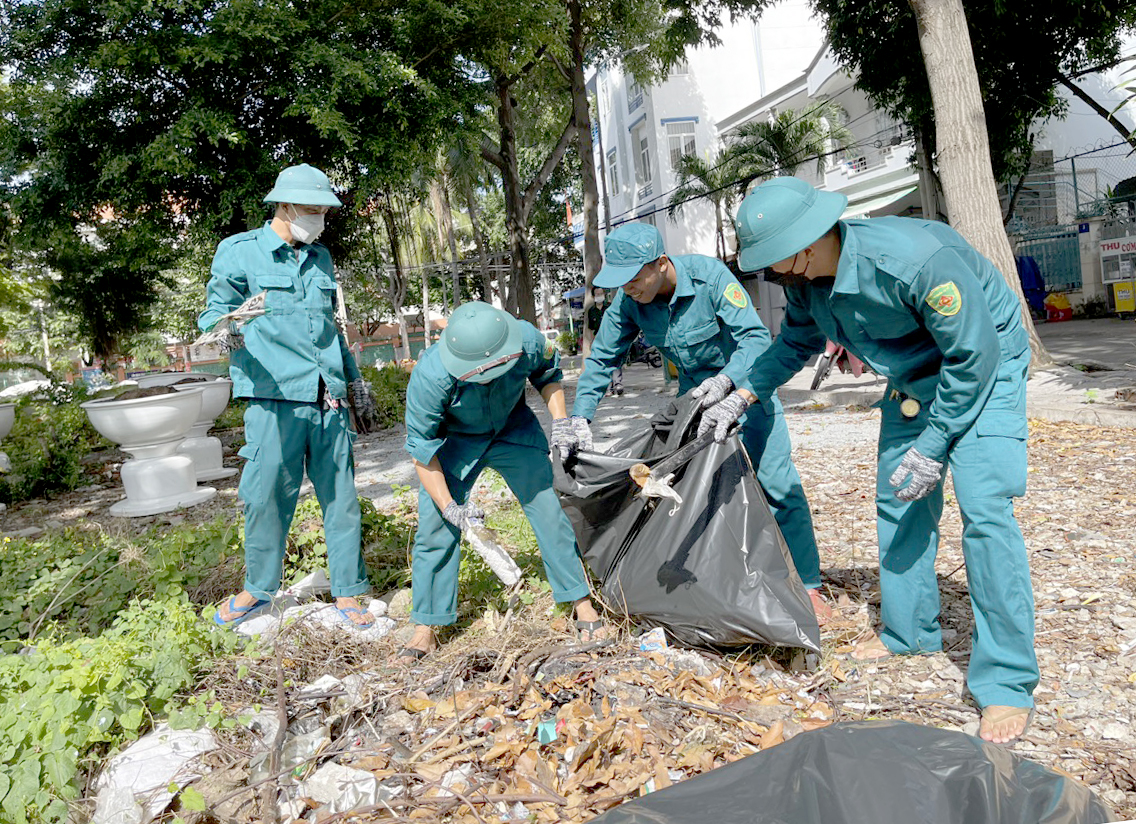 Lực lượng dân quân phường 1 thu gom rác thải tại khuôn viên 21 Thống Nhất.
