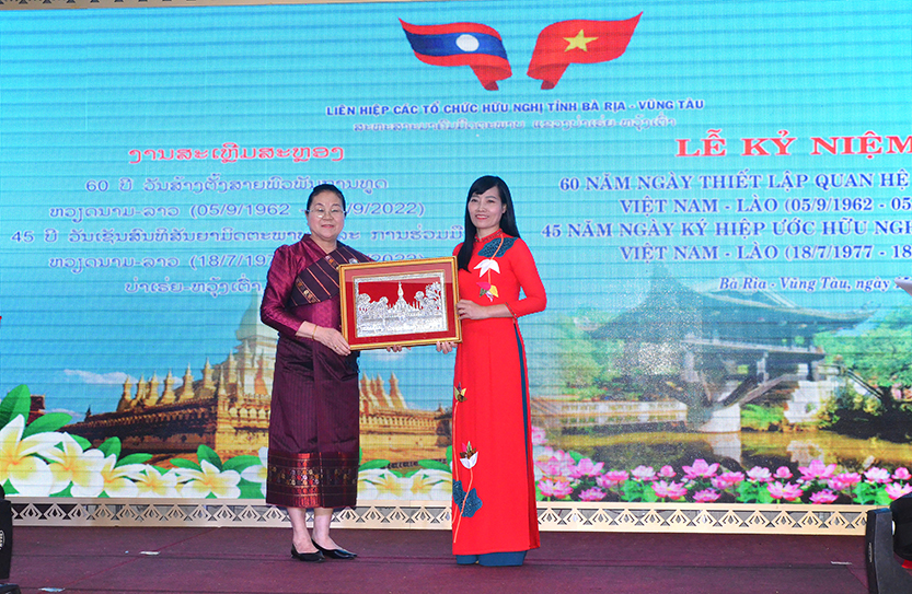 Bà Phimpha Keomixay (trái), Tổng Lãnh sự nước CHDCND Lào tại TP.Hồ Chí Minh tặng quà lưu niệm cho bà Đỗ Thị Như Mai, Chủ tịch Liên hiệp các tổ chức hữu nghị tỉnh.