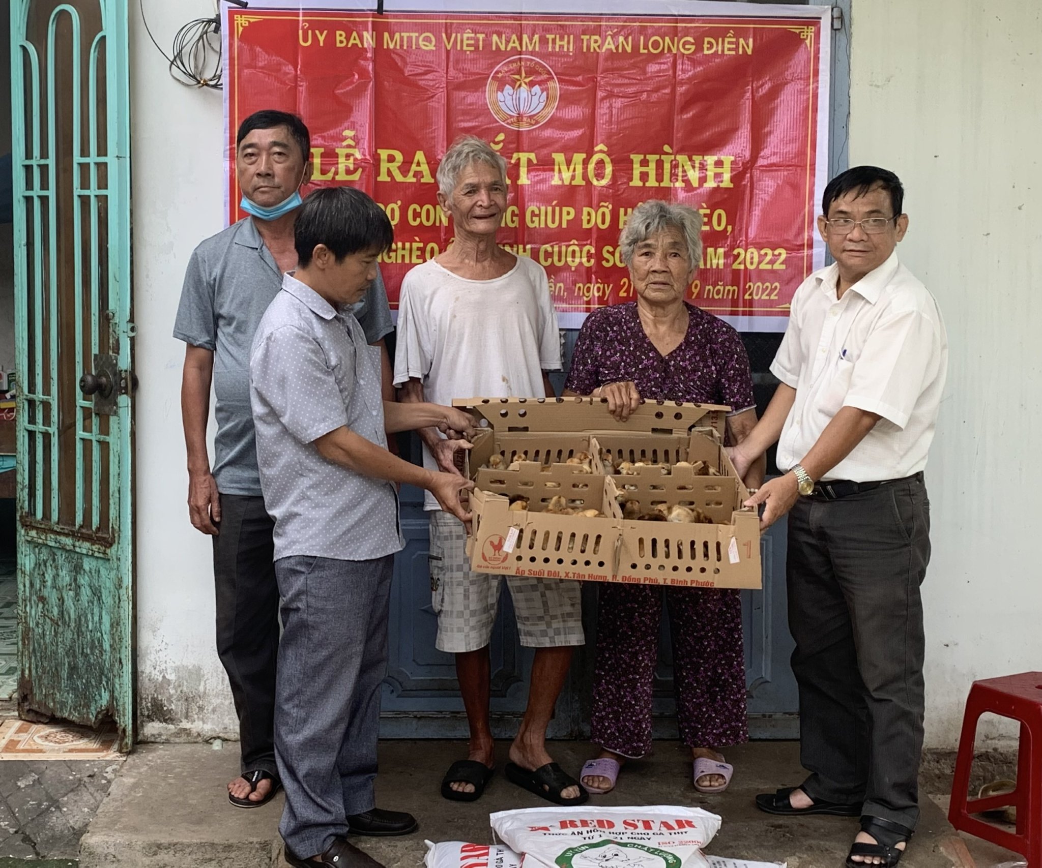 Lãnh đạo Ủy ban MTTQVN thị trấn Long Điền trao gà và thức ăn chăn nuôi cho gia đình ông Nguyễn Văn Hoa. 