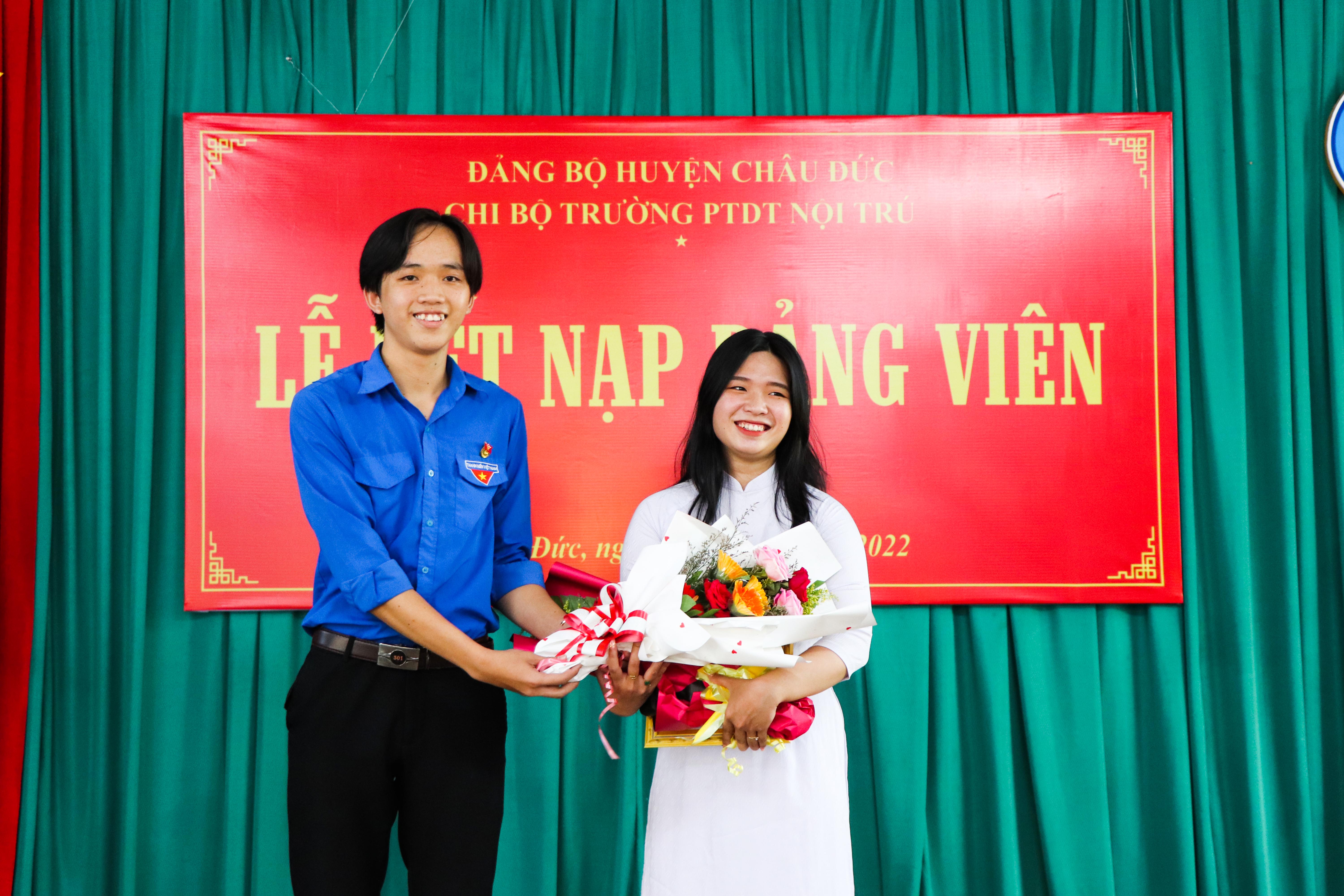Anh Trần Thanh Tú, Phó Bí thư Đoàn trường tặng hoa chúc mừng đảng viên mới.