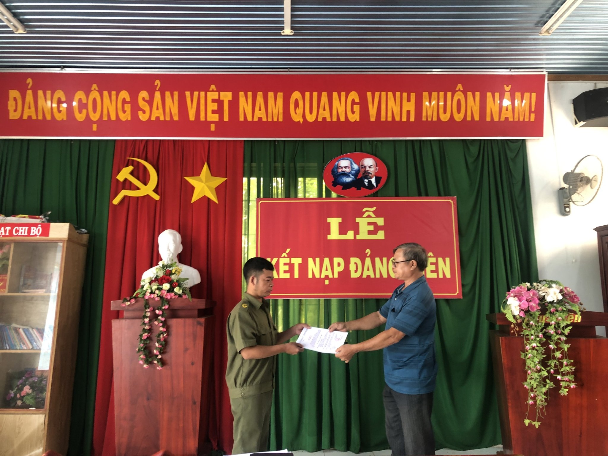 Đại diện Chi bộ ấp Bàu Chiên, xã Tân Lâm, huyện Xuyên Mộc trao quyết định kết nạp đảng cho đảng viên Lý Quang Hiếu (bên trái).
