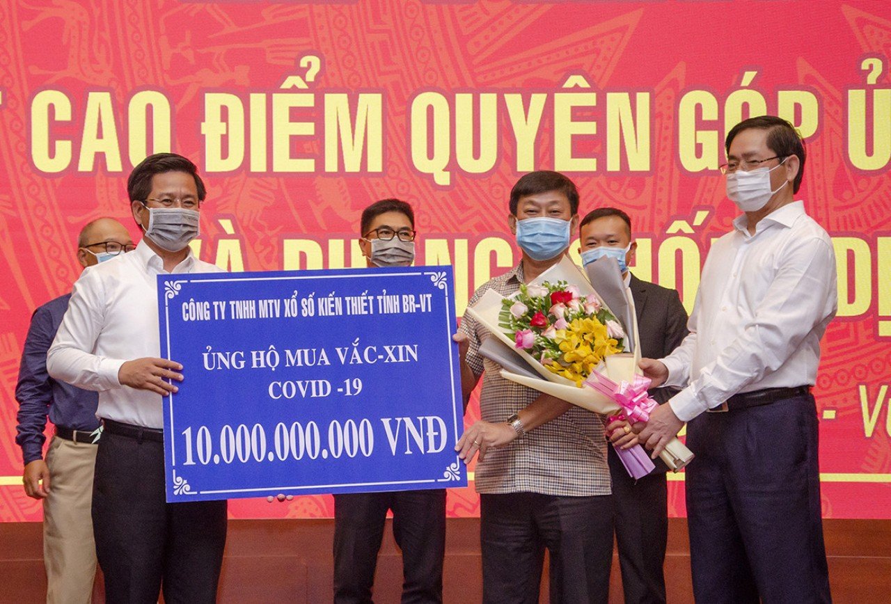 Ông Phạm Viết Thanh, Ủy viên Trung ương Đảng, Bí thư Tỉnh ủy, Chủ tịch HĐND tỉnh tặng hoa tri ân các DN, doanh nhân tại lễ phát động Quỹ phòng, chống dịch COVID-19.