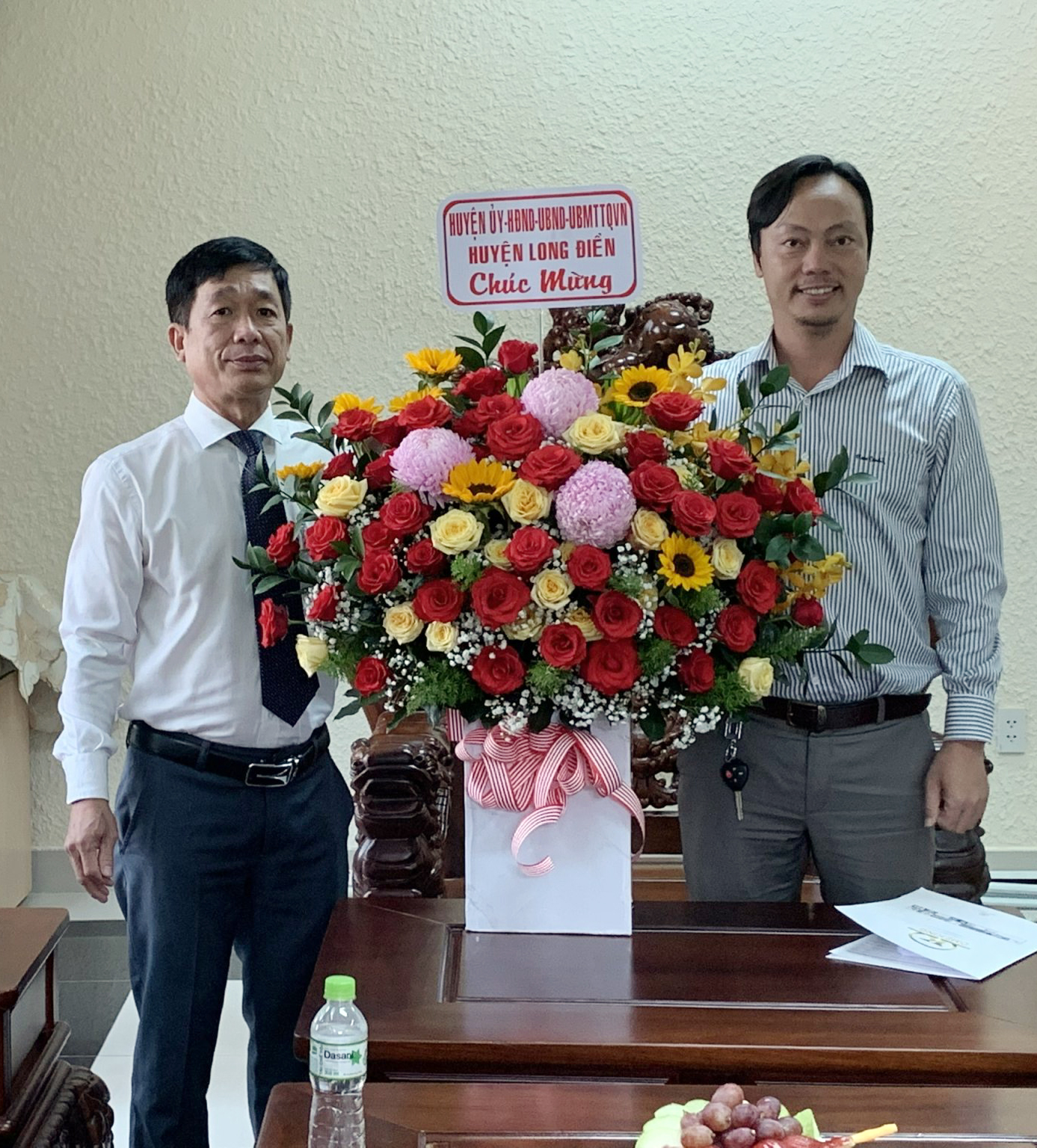 Ông Trần Kim Phúc (bên trái), Phó Chủ tịch UBND huyện Long Điền tặng hoa chúc mừng đại diện Công ty CP Đầu tư Xây dựng Tân Phước Thịnh.