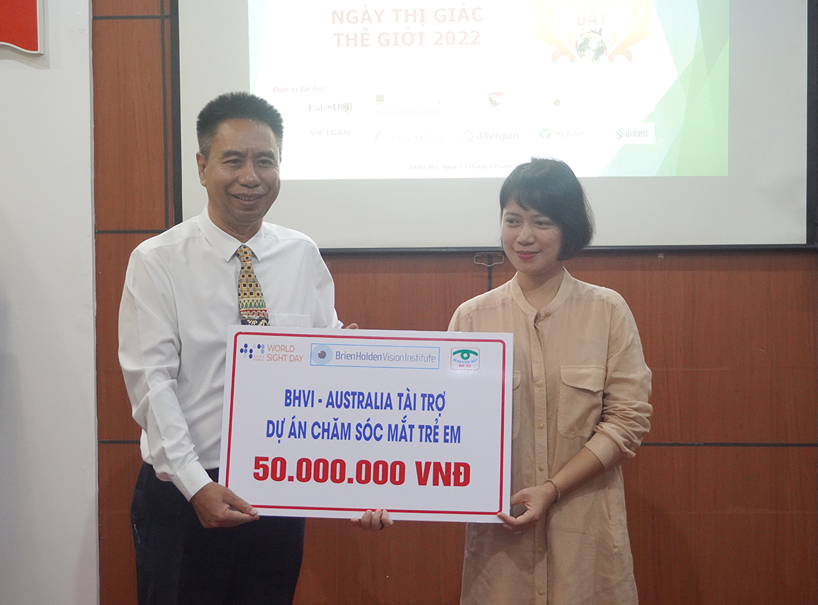 Đại diện Viện mắt Brien Holden (Úc) tặng bảng tượng trưng 50 triệu đồng cho Chương trình Chăm sóc mắt trẻ em.