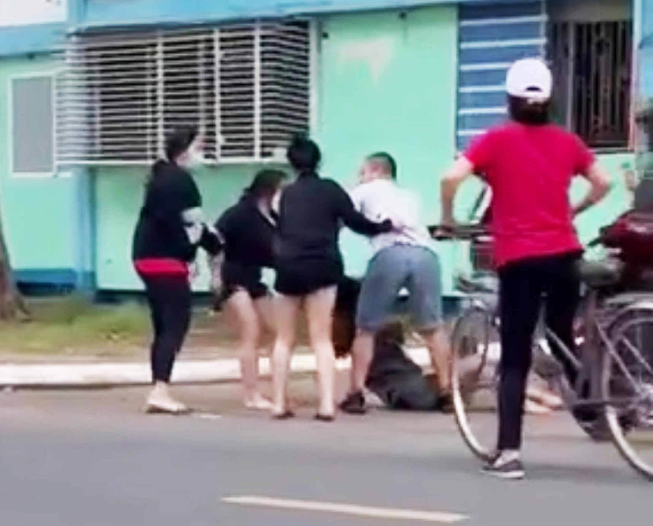 Nhóm người đánh nữ sinh U. chỉ dừng lại sau khi người đàn ông lao vào can ngăn (Ảnh cắt từ clip).