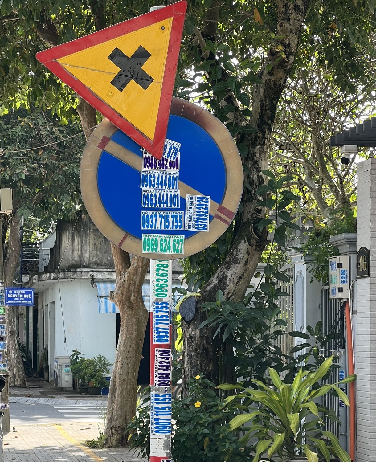 Một biển báo giao thông bị dán số điện thoại quảng cáo che kín. Ảnh: ATGT Bà Rịa.