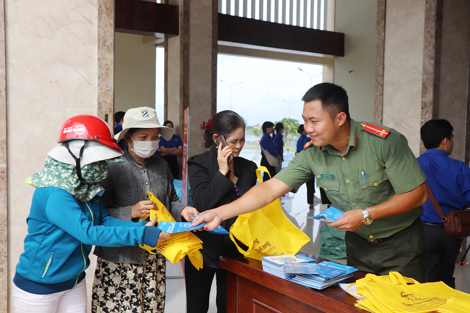 Đoàn viên thanh niên Công an tỉnh phát tờ rơi, tặng túi vải tuyên truyền người dân bảo vệ môi trường.
