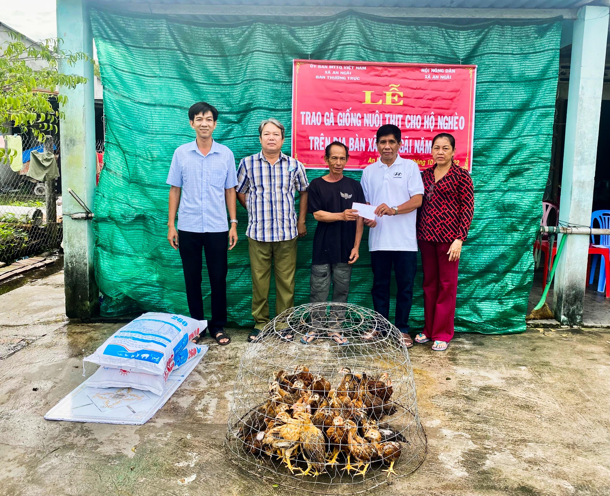 Ông Lương Tuấn Hải (bên trái), Phó Chủ tịch UBND xã An Ngãi cùng các Hội đoàn thể trao gà giống cho hộ ông Lê Mộng Hoàng, ở ấp An Phước.