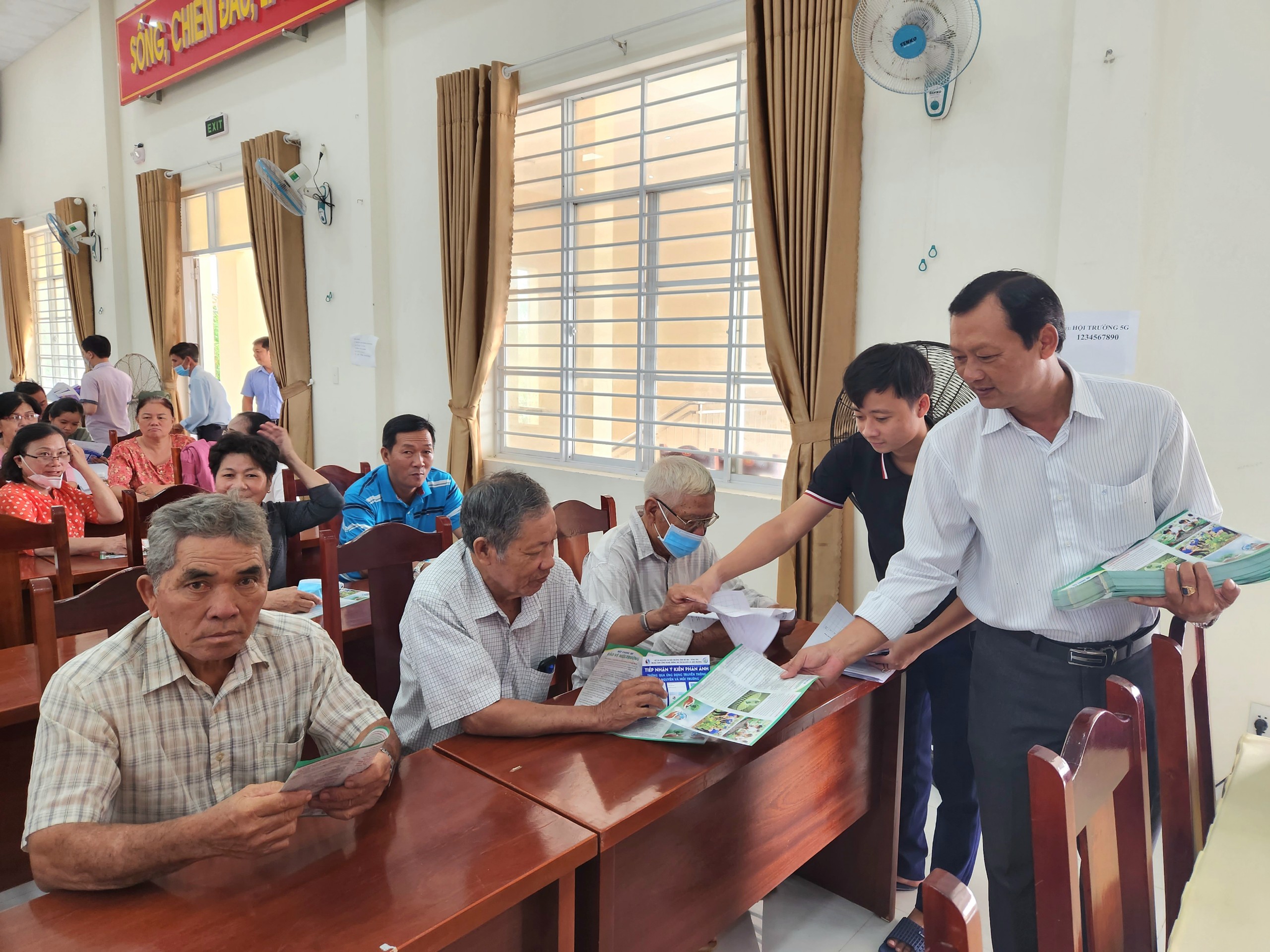 Ban tổ chức phát tờ rơi tuyên truyền bảo vệ môi trường đến người dân tại hội nghị.
