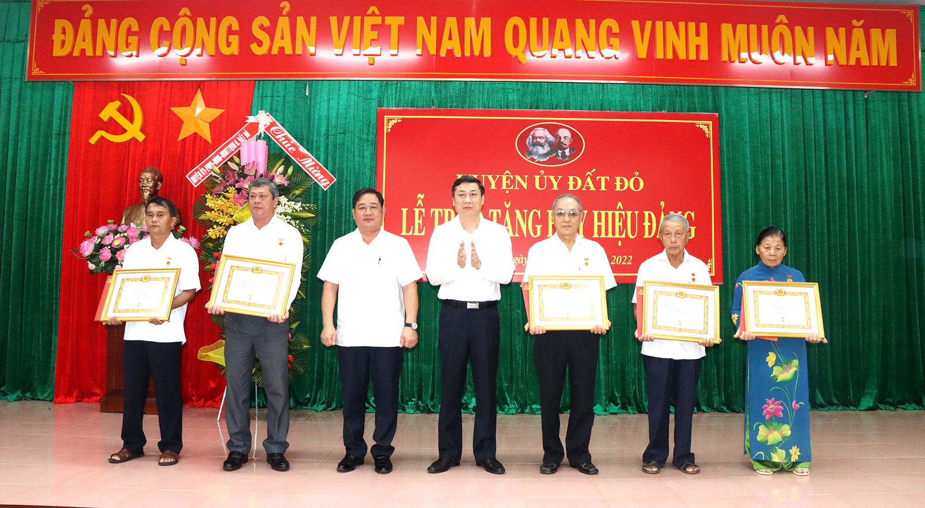 Ông Nguyễn Công Danh, Bí thư Huyện ủy Đất Đỏ và ông Trần Thanh Hùng, Phó Bí thư Thường trực Huyện ủy trao Huy hiệu, tặng quà chúc mừng các đảng viên. Ảnh: TUẤN VŨ