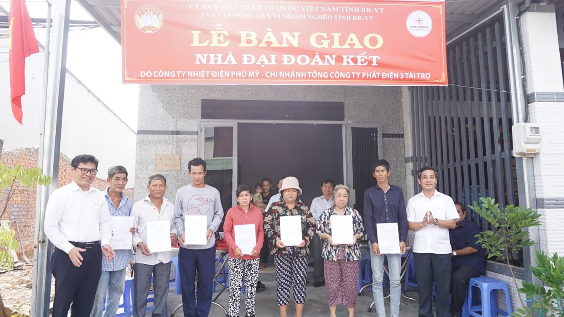 Ông Nguyễn Kế Toại, Phó Chủ tịch UBMTTQ Việt Nam tỉnh Bà Rịa - Vũng Tàu (bìa phải) và ông Trần Hữu Thanh, Phó Giám đốc Công ty Nhiệt điện Phú Mỹ (bìa trái) trao Quyết định bàn giao nhà “Đại đoàn kết” cho các hộ dân tại TX.Phú Mỹ.